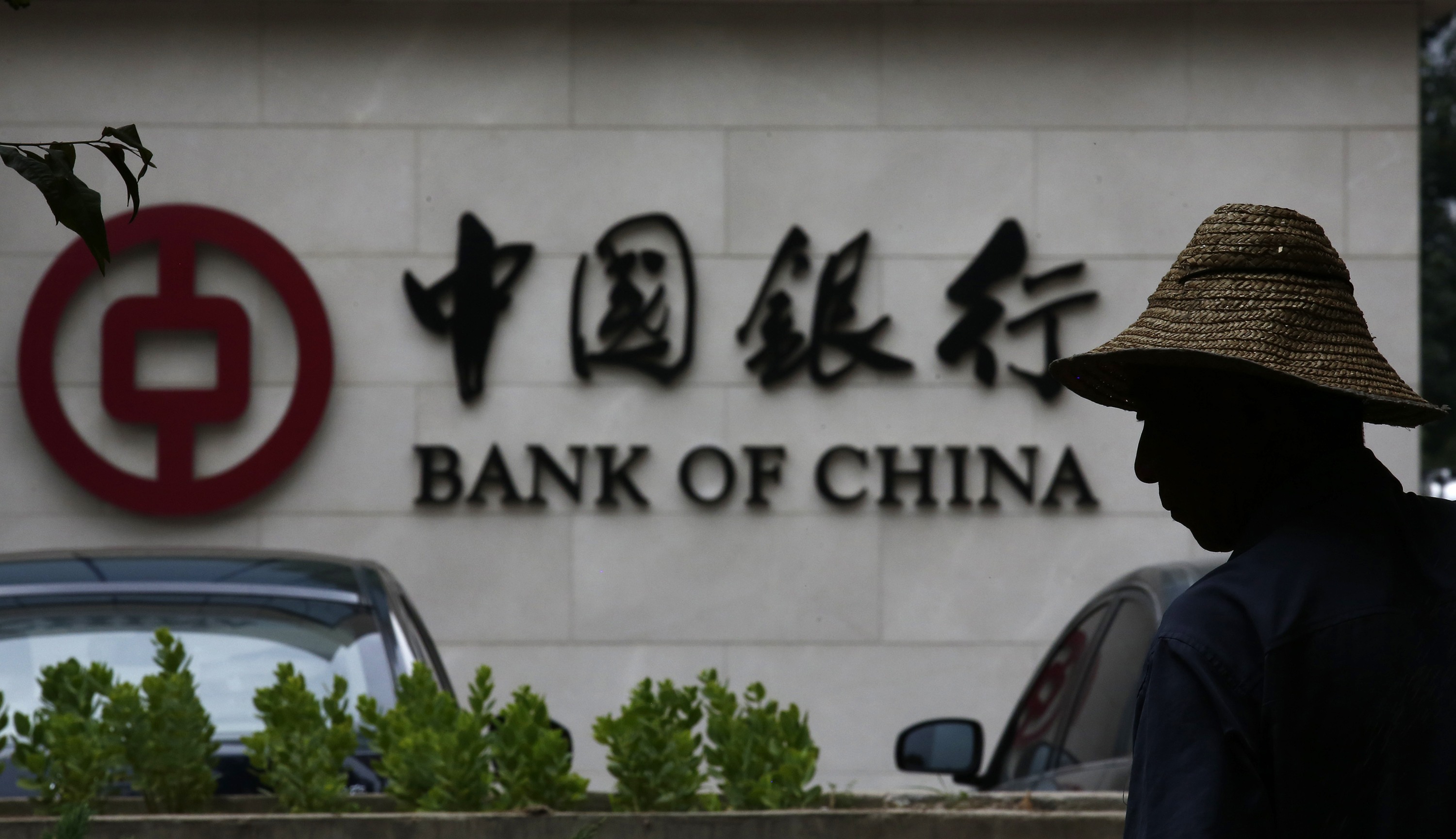 A man silhouetted in front of a Bank of China's logo at its branch office in Beijing. Photo: Reuters