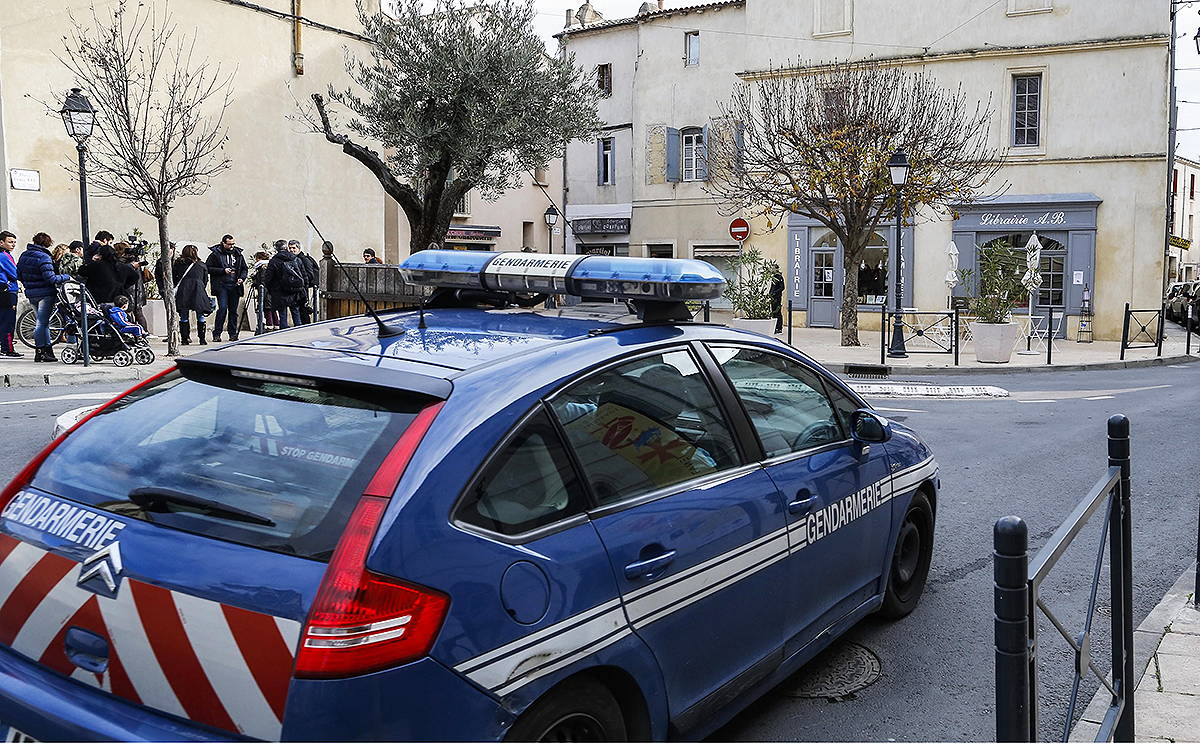 Police officers and members of press stand outside a building in the centre of Lunel, southern France, on January 27. Photo: EPA