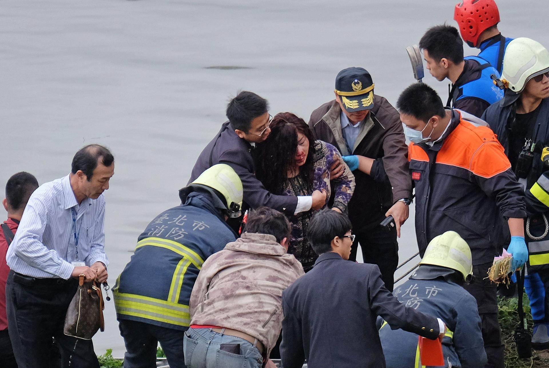 An injured passenger is helped to the riverbank. Photo: AFP