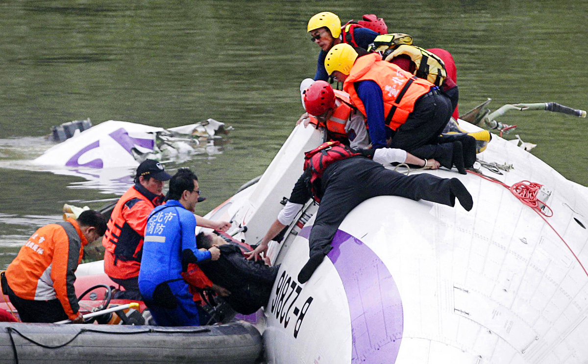 Rescuers pull a passenger from Flight GE235. Photo: Reuters