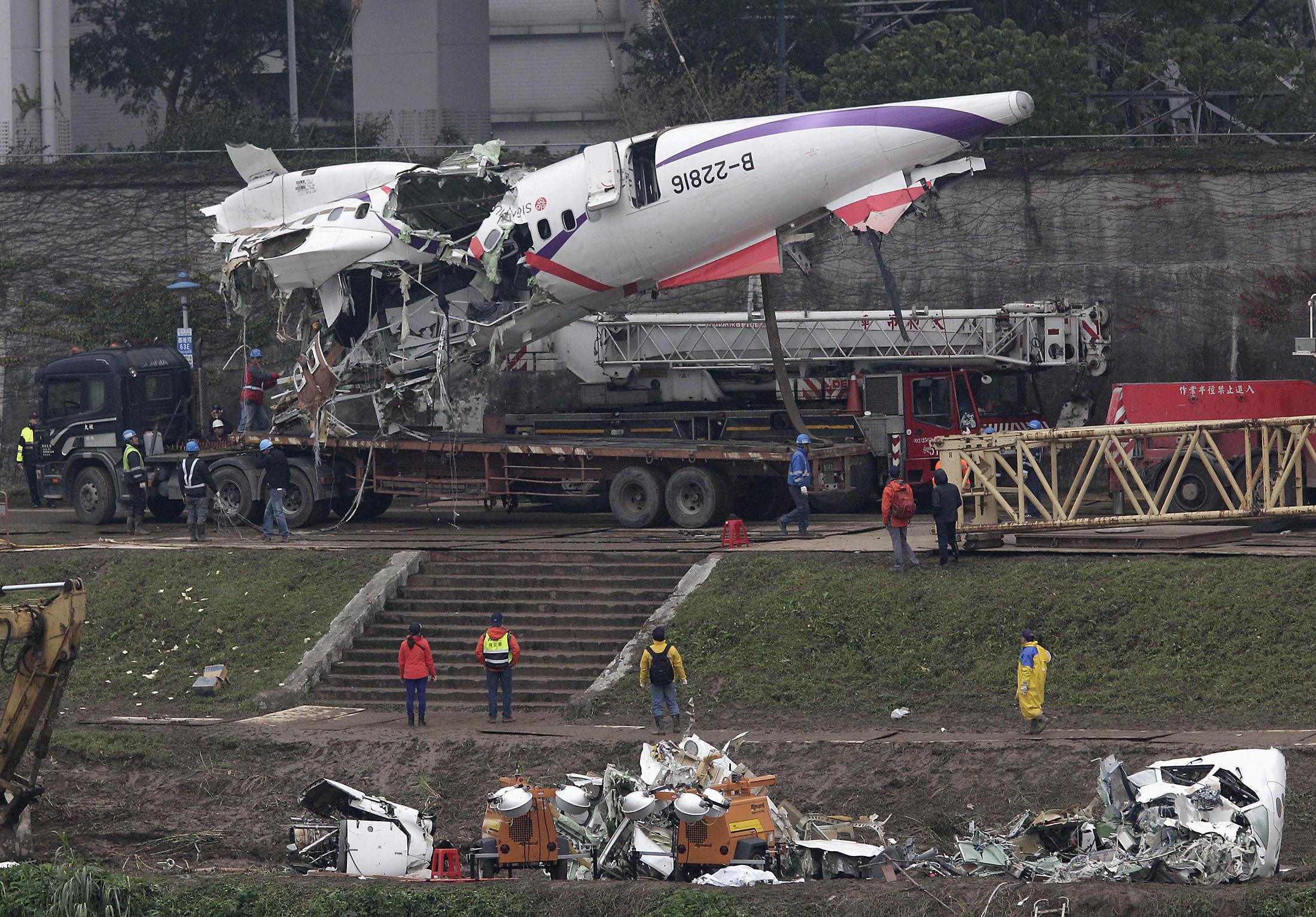 Emergency teams remove pieces of wreckage at the site of the crashed TransAsia Airways plane Flight GE235 in New Taipei City. Photo: Reuters