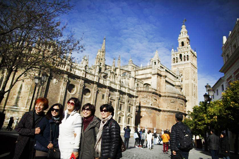 Tourists pose for photographs next to a cathedral in the Andalusian capital of Seville in southern Spain. Photo: Reuters