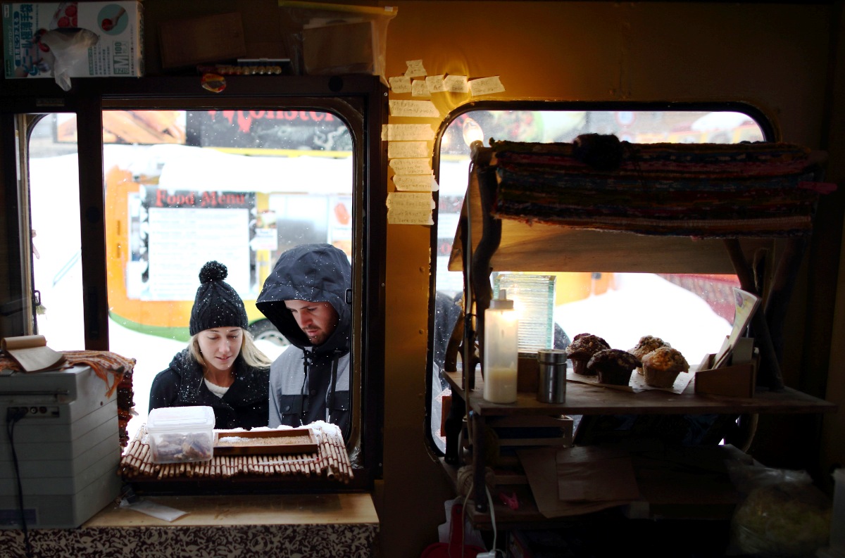 Visitors look at a menu displayed outside a food truck in Hokkaido, Japan. Photo: Bloomberg