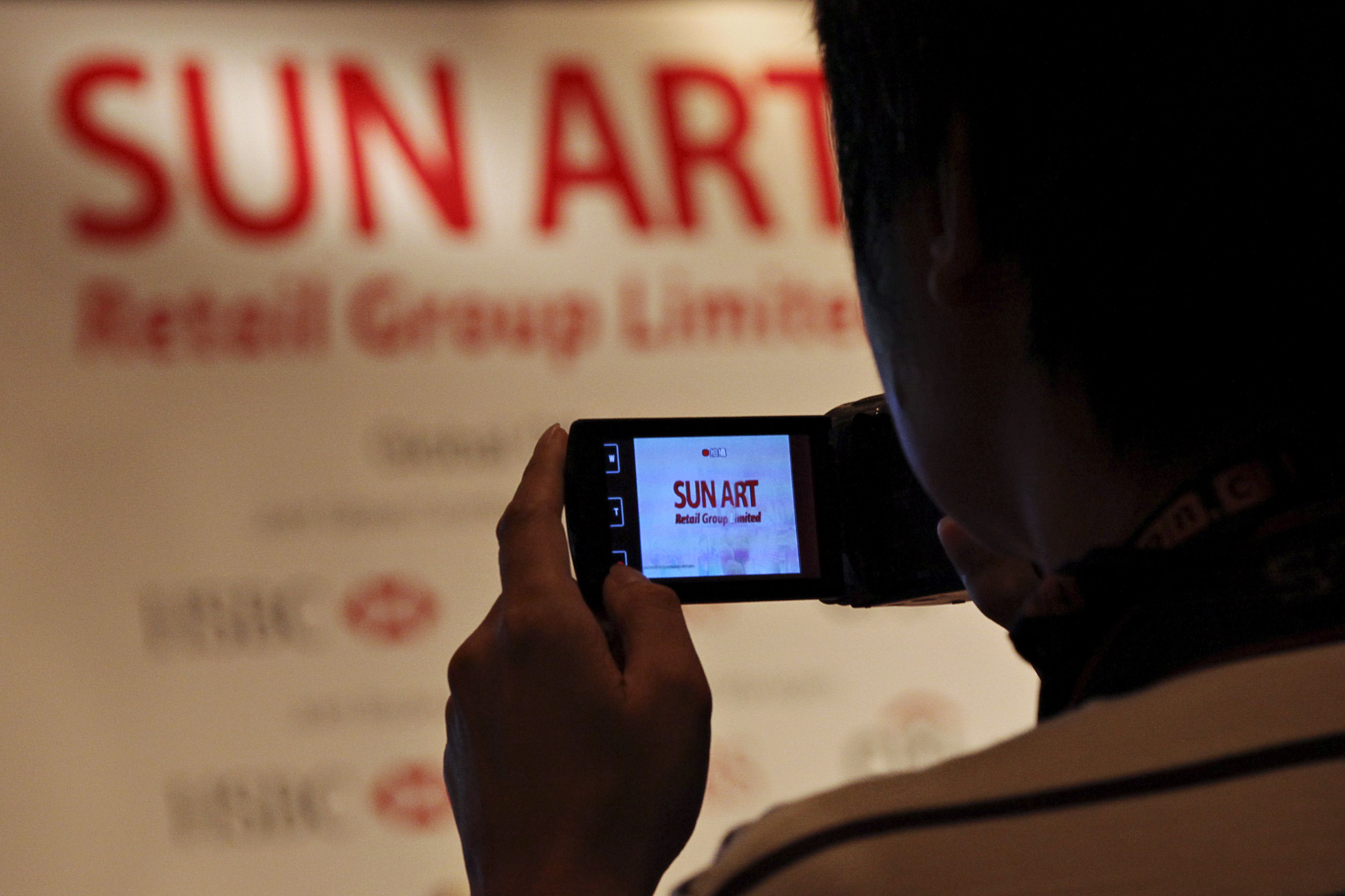 A man takes video at a briefing by Sun Art Retail, mainland China's largest hypermart operator. Photo: AFP