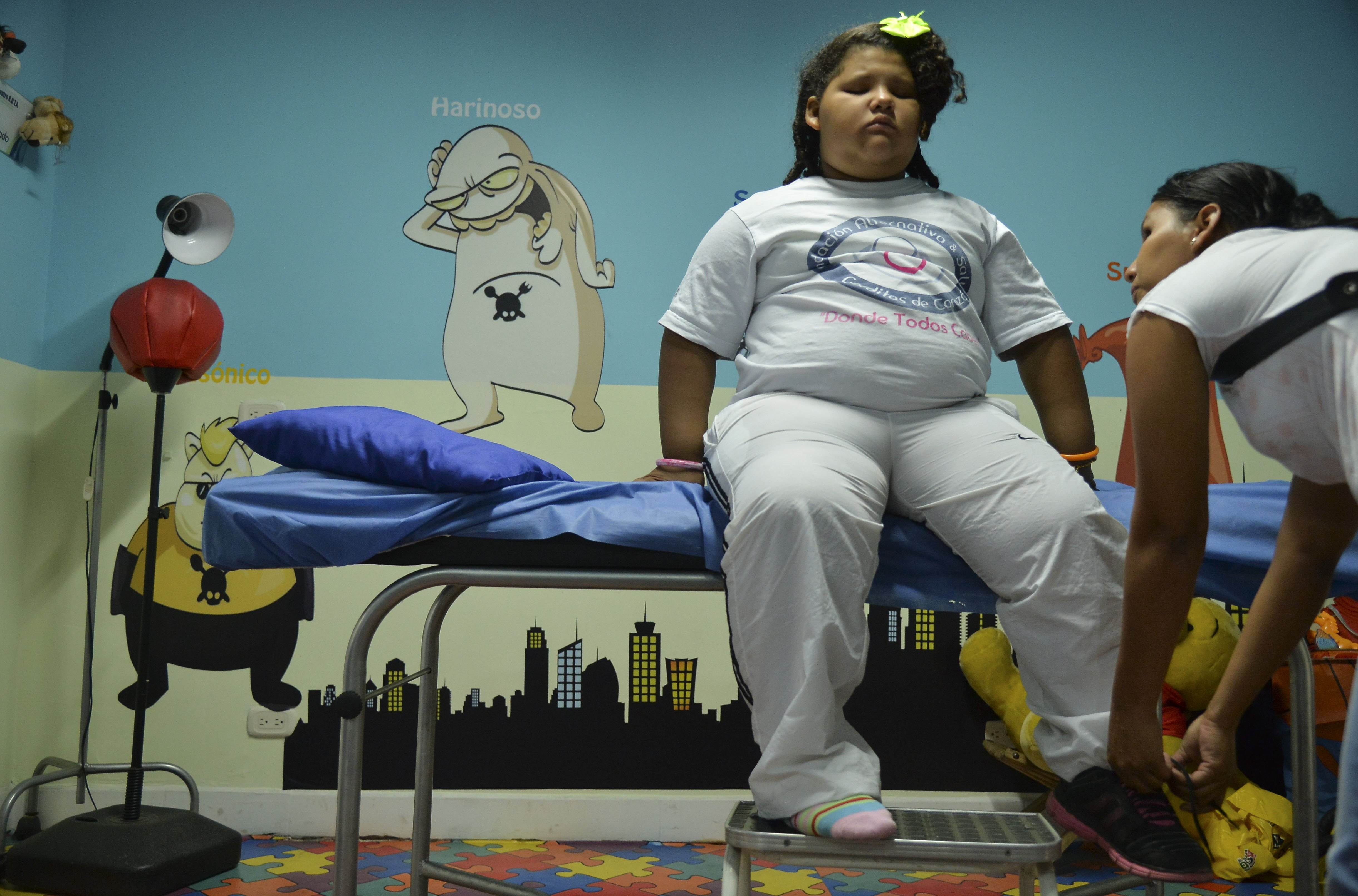 An eight-year-old Colombian girl, whose ideal weight is 24kg but weighs 90kg, waits for a medical check-up in Medellin, Colombia. Photo: AFP