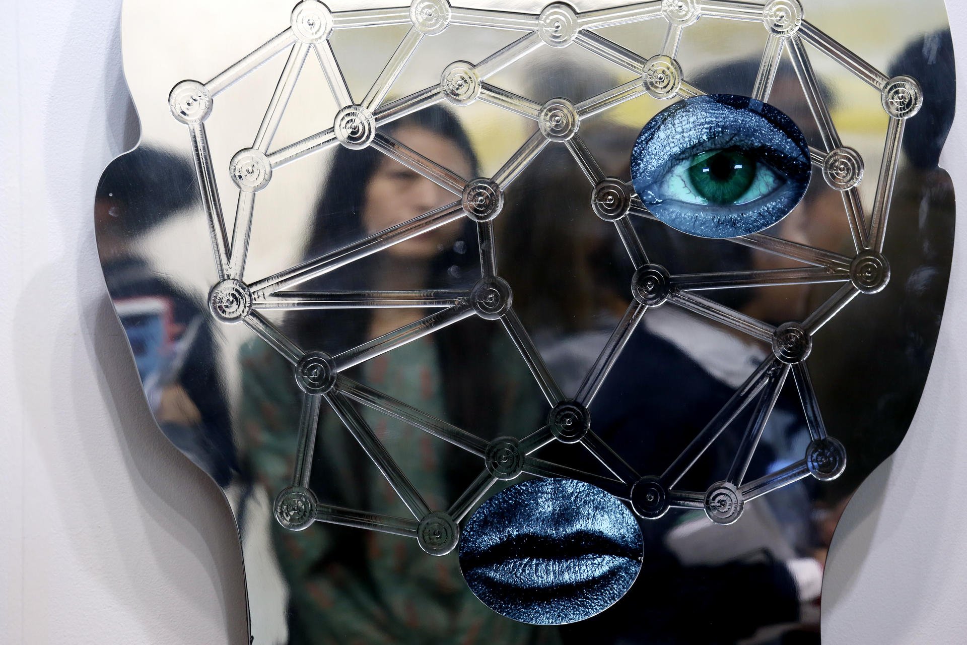 A visitor walks behind an artwork by Tony Oursler at the Art Basel extravaganza.Photos: Nora Tam