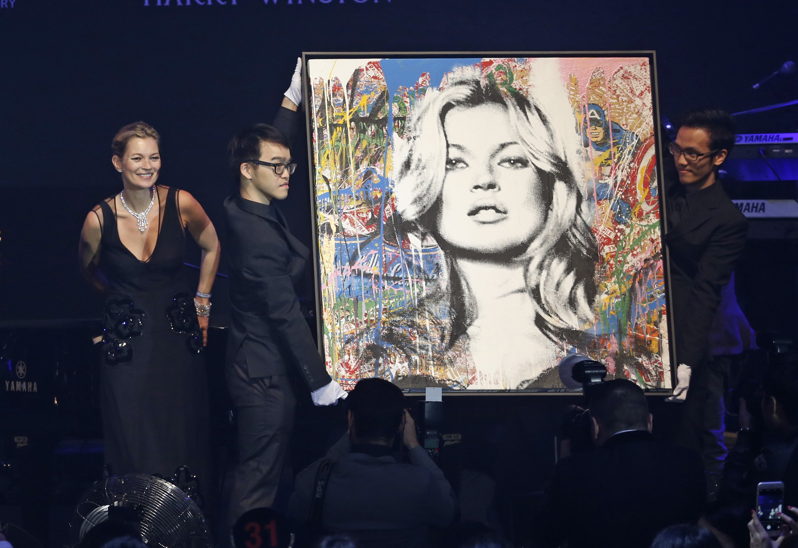 Kate Moss, left, stands next to the artwork "Kate Moss" created by French street artist Mr. Brainwash. Photo: AP
