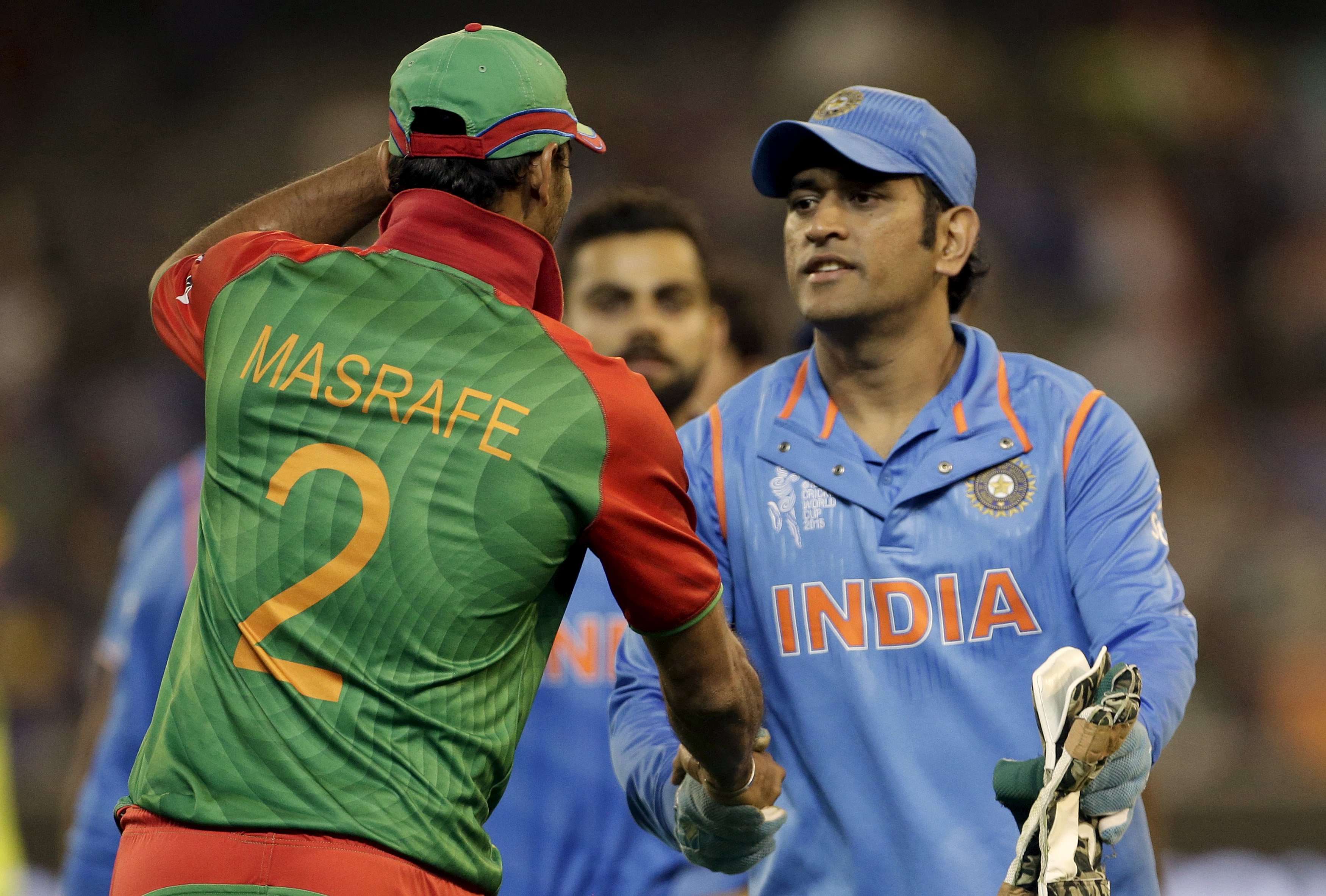 Bangladesh captain Mashrafe Mortaza (left) shakes hands with victorious India captain MS Dhoni after India's 109-run quarter final win over Bangladesh. Photo: Reuters