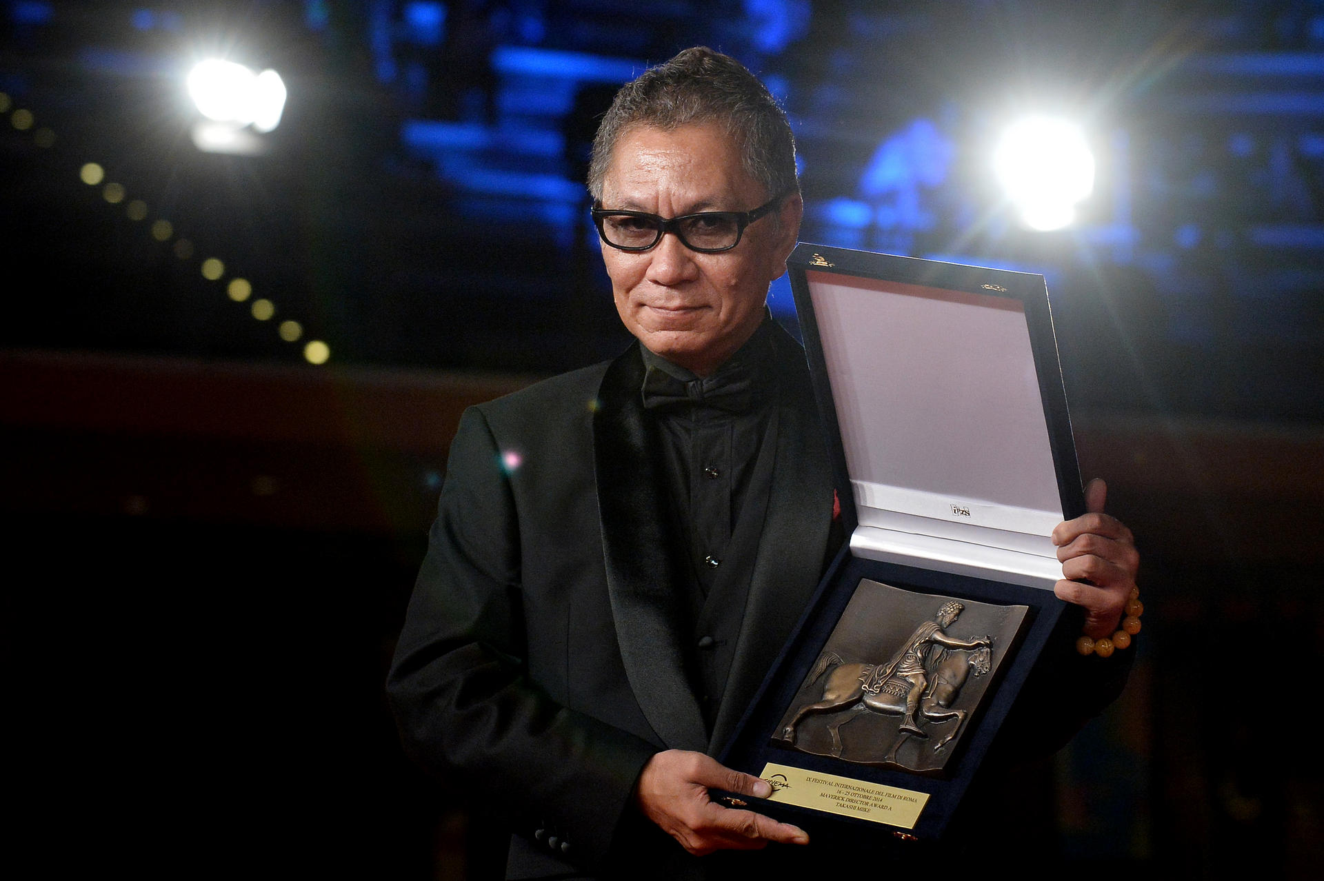 Takashi Miike with his maverick director award from the Rome Film Festival. He adapted his latest films, Over Your Dead Body and As the Gods Will, from a kabuki play and manga, respectively. Photo: AFP