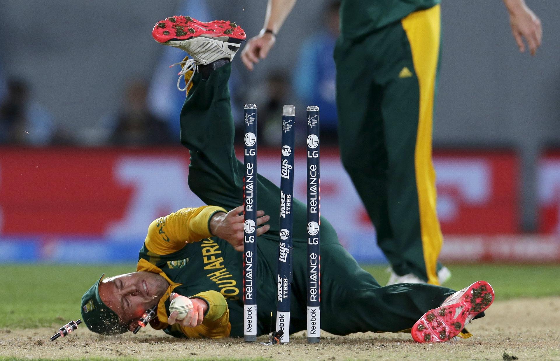 South African captain AB de Villiers tumbles over the stumps in a failed attempt to run out New Zealand's Corey Anderson. Photo: Reuters