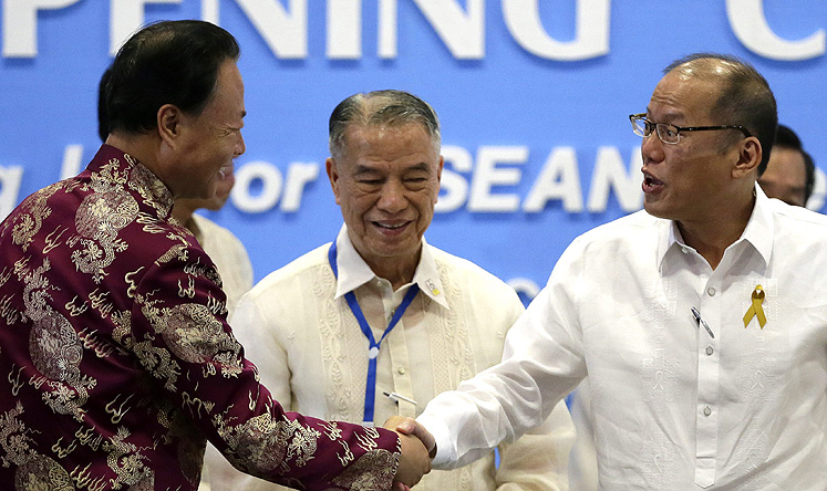 The Philippine's President Benigno Aquino (right) and China's ambassador in Manila Zhao Jianhua (left) shake hands at a Filipino-Chinese Chamber of Commerce conference on Friday. Photo: EPA