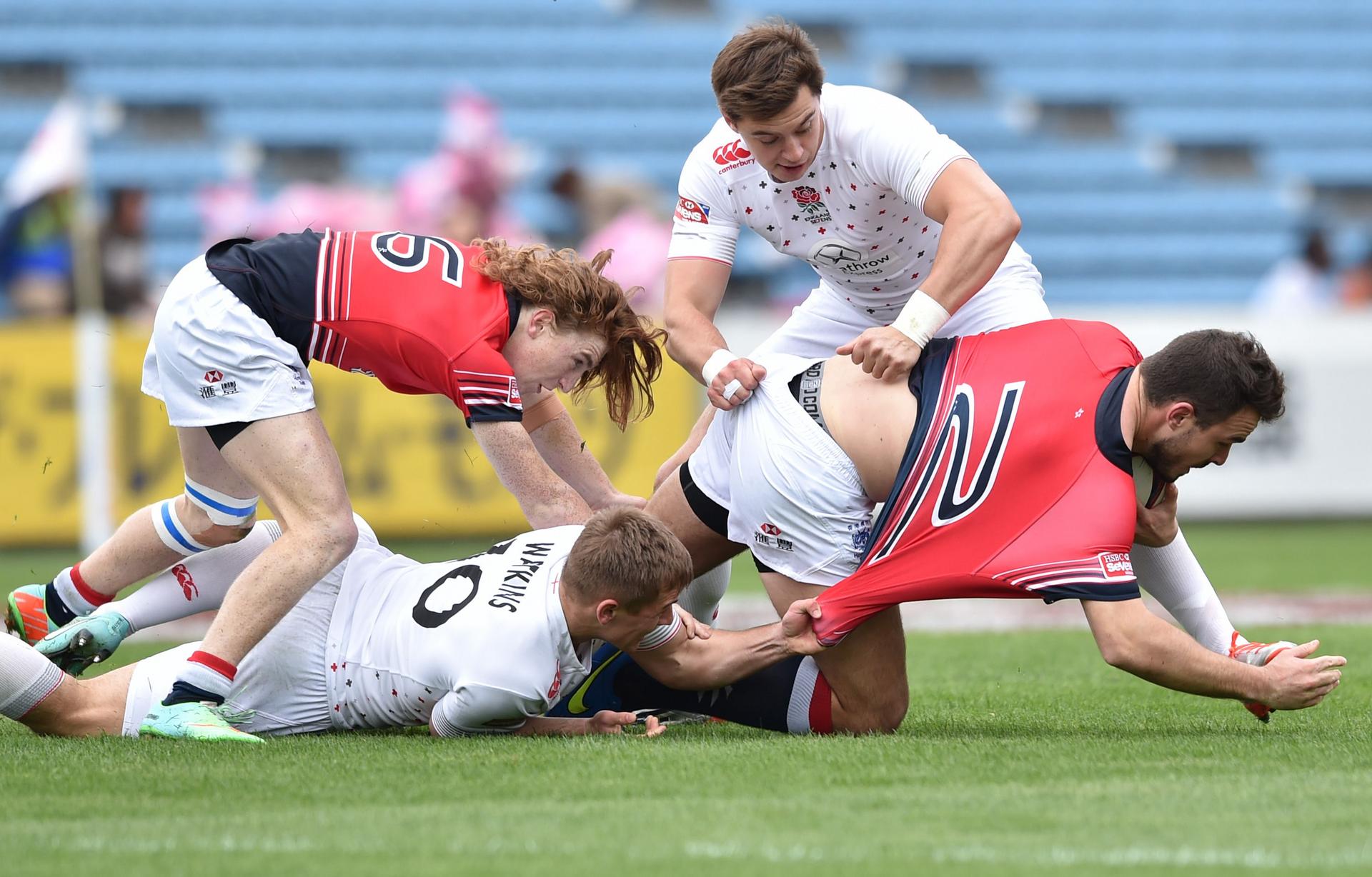 Jack Capon is held up by England's Josh Watkins and Alex Gray, while Hong Kong debutant Hugo Stiles provides support at the Japan Sevens. Photos: AFP