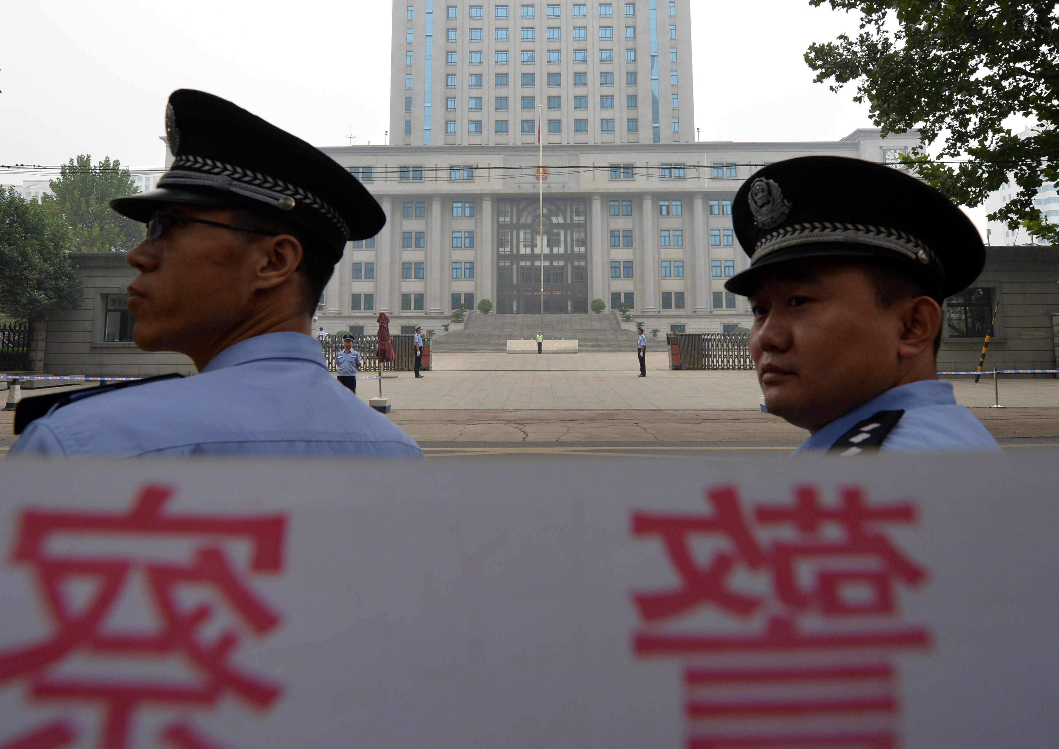 Police stand guard outside the Intermediate People's Court in Jinan, Shandong. For judges to be credible, neutrality is crucial. Photo: AFP 