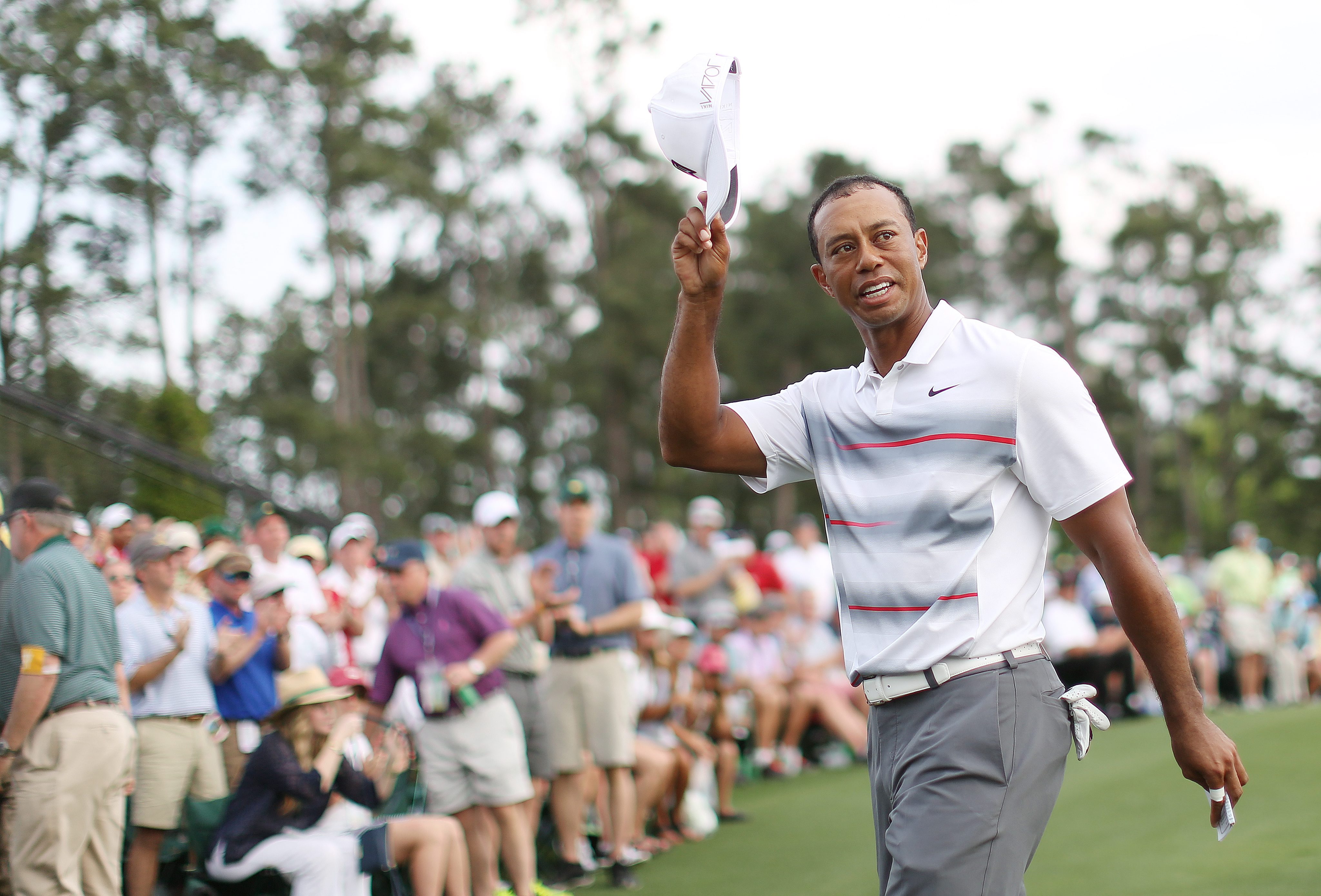 Woods tips his hat after finishing his round. Photo: EPA