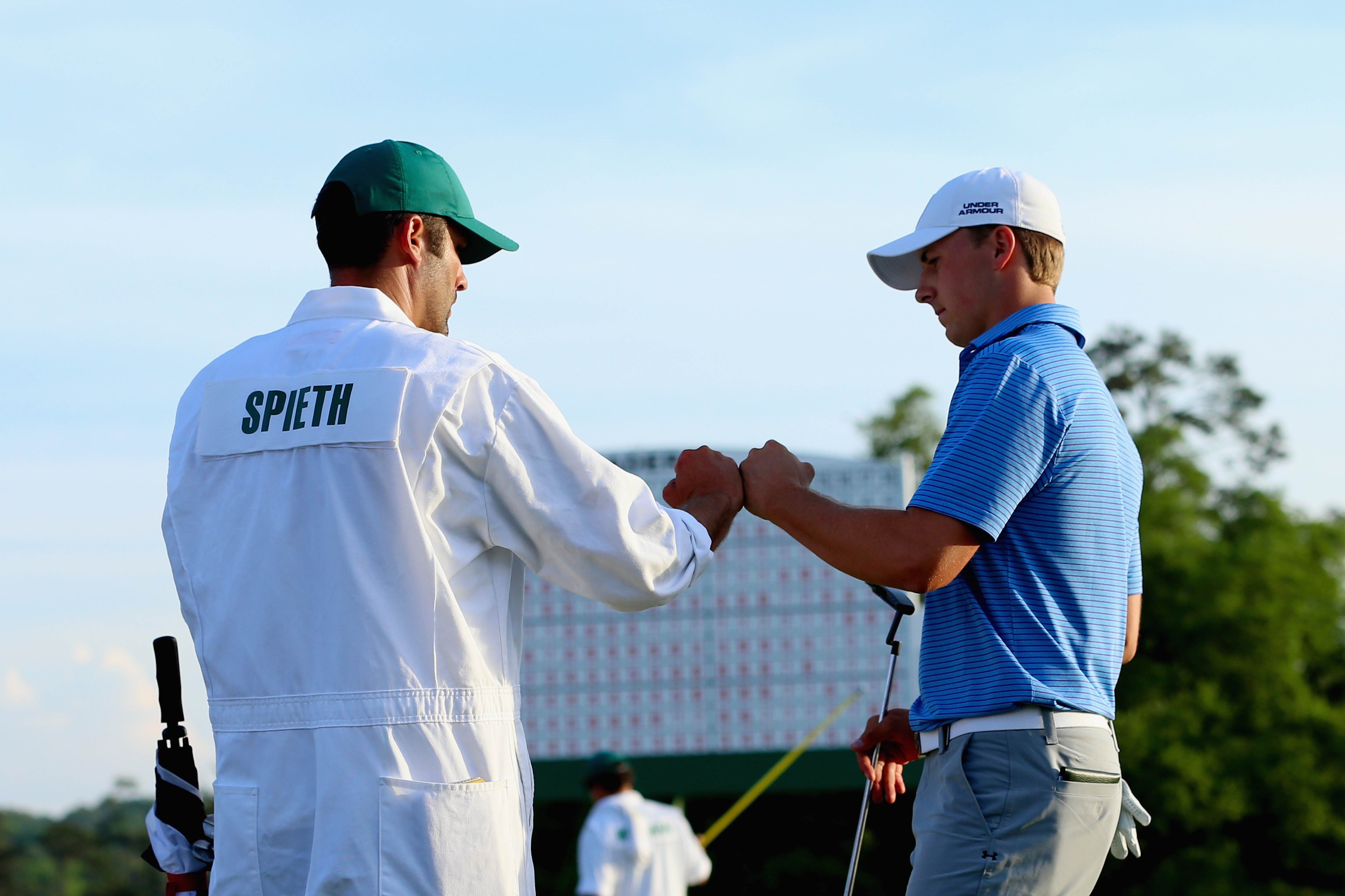 Jordan Spieth and his caddy bump fists after holing out on 18. Photo: AFP