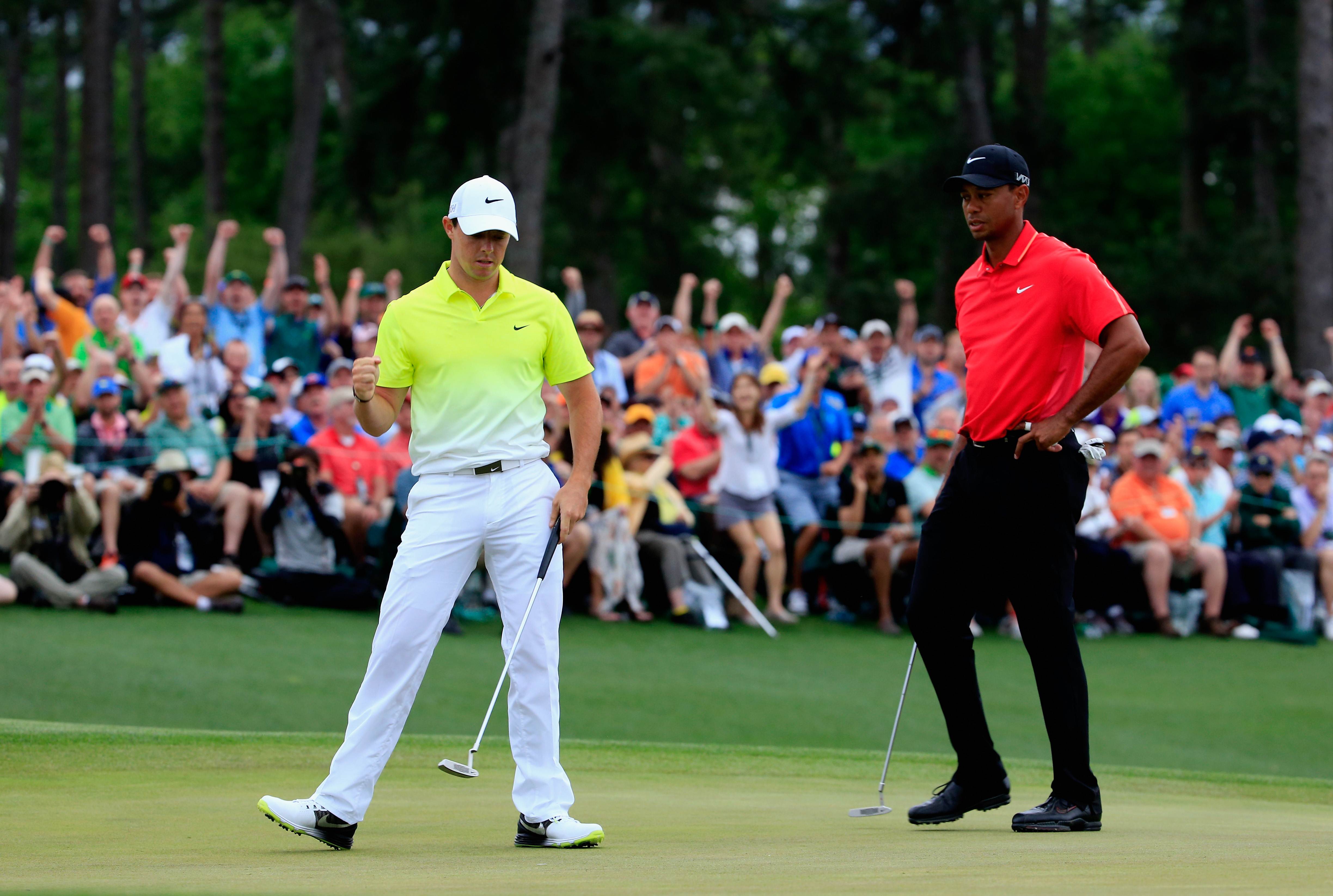 Rory McIlroy birdies the last hole at Augusta National as playing partner Tiger Woods looks on. Photo: AFP