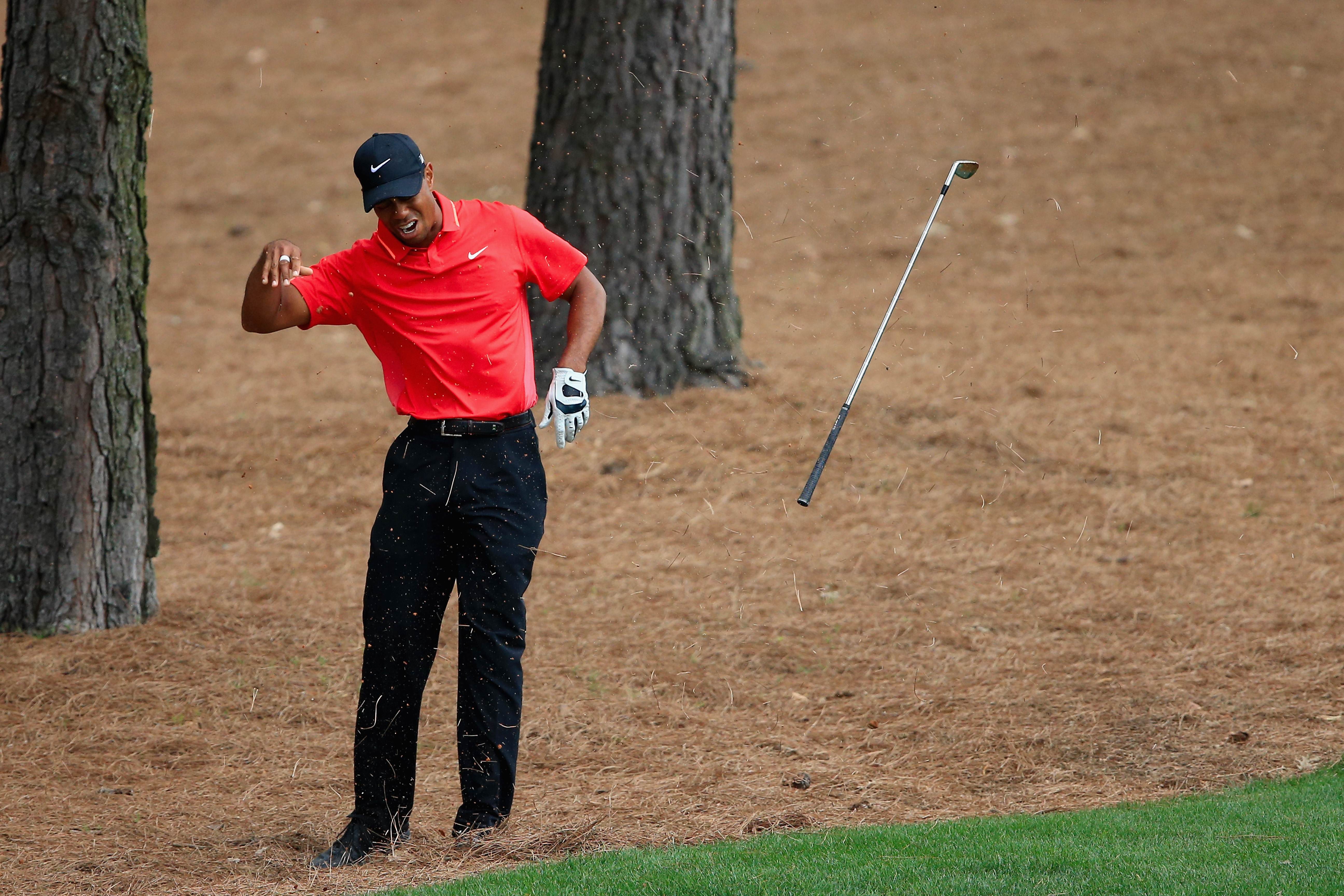Tiger Woods flinches after hitting a tree root under the pine straw on the ninth hole during the final round of the Masters. "A bone kind of popped out and the joint kind of went out of place, but I put it back in," Woods said. Photo: AFP