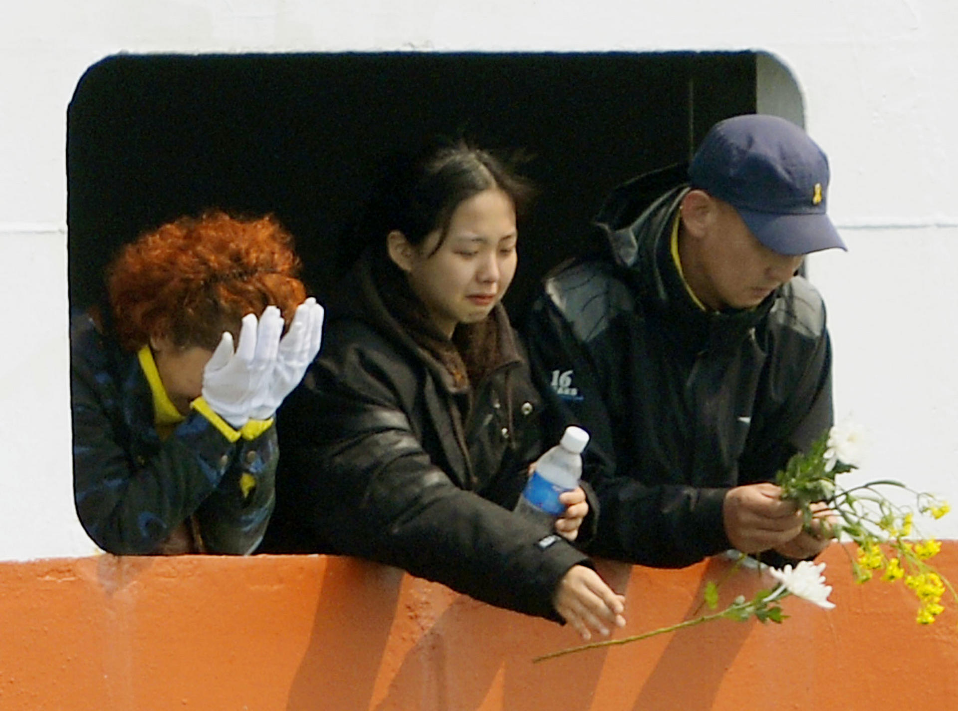 Relatives weep and offer flowers at the accident site. Photo: Kyodo