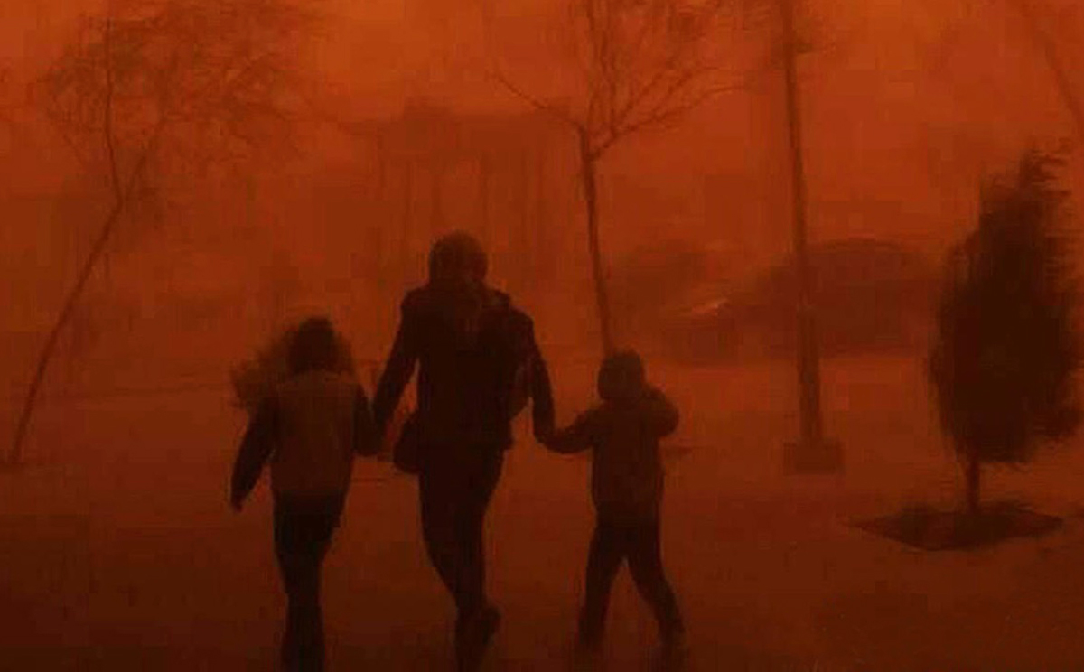 People walk through a sandstorm shrouding Beijing in dust. Photo: SCMP Pictures