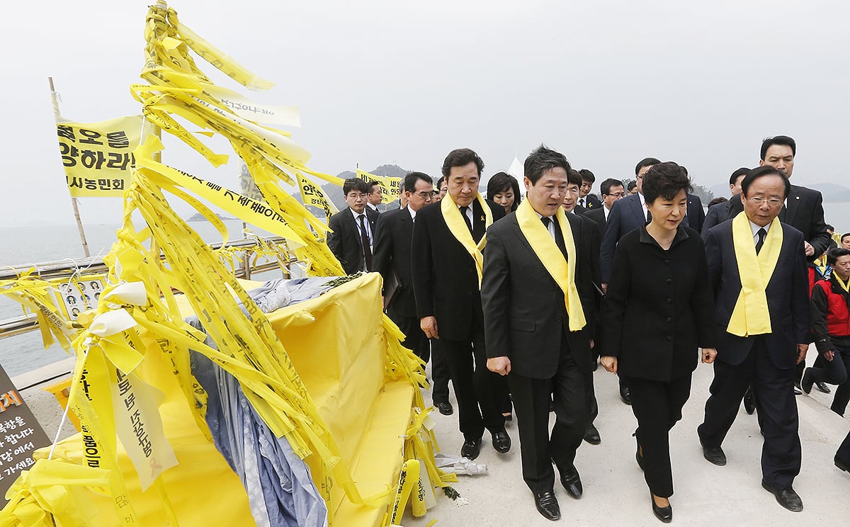 South Korean President Park Geun-hye, center front, passes by yellow ribbons tied with messages for the victims of the sunken ferry Sewol as she arrives to offer her condolences to the bereaved relatives of the victims at a port in Jindo. Photo: AP