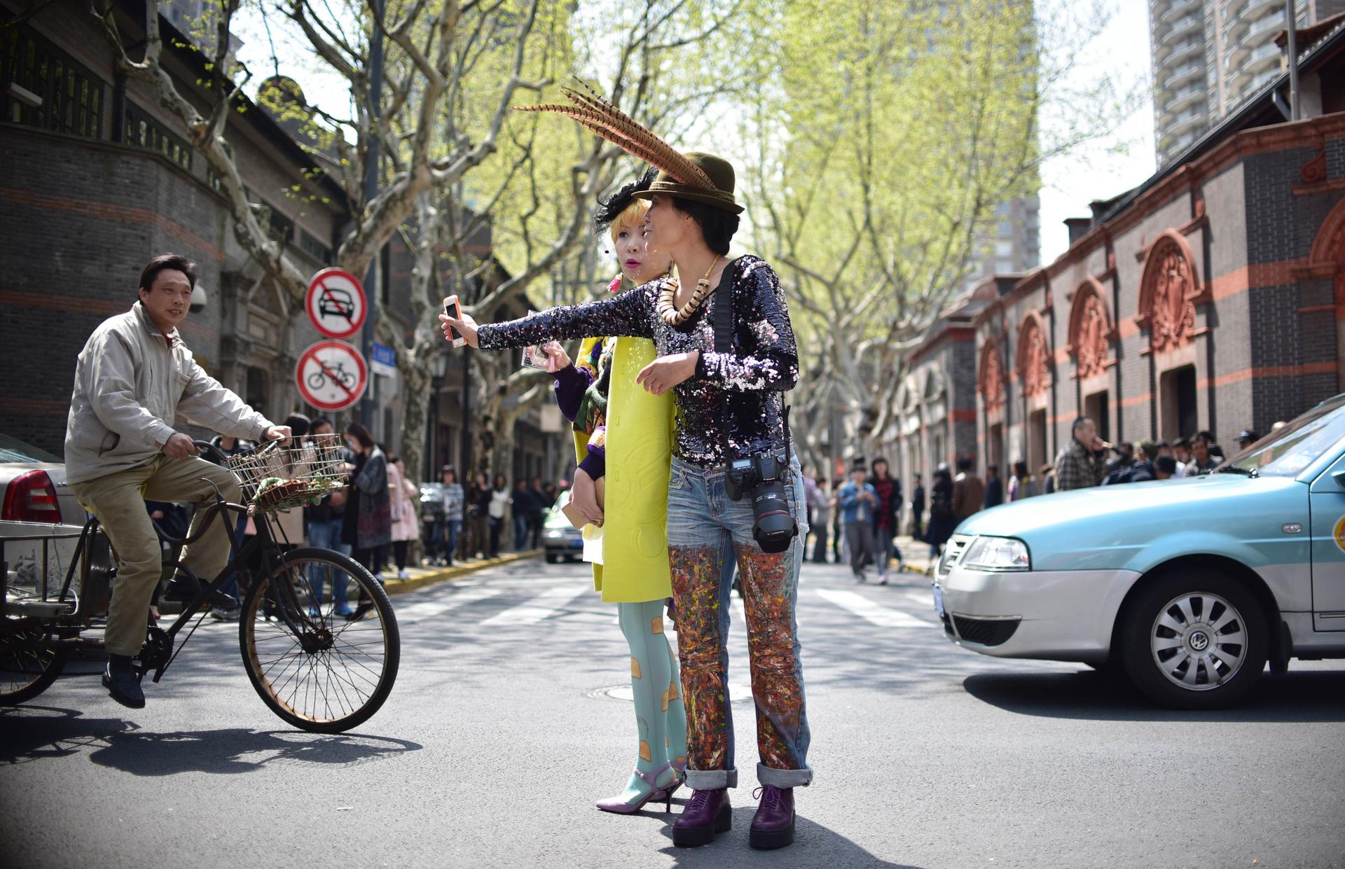 Two women take a selfie before a show during Shanghai Fashion Week. Photo: AFP