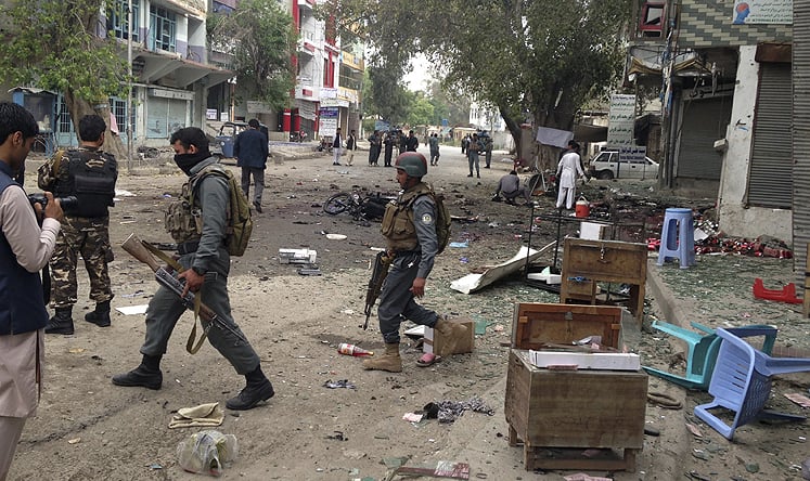 Afghan security forces members inspect the site of a suicide attack near a new Kabul Bank in Jalalabad. Photo: AP