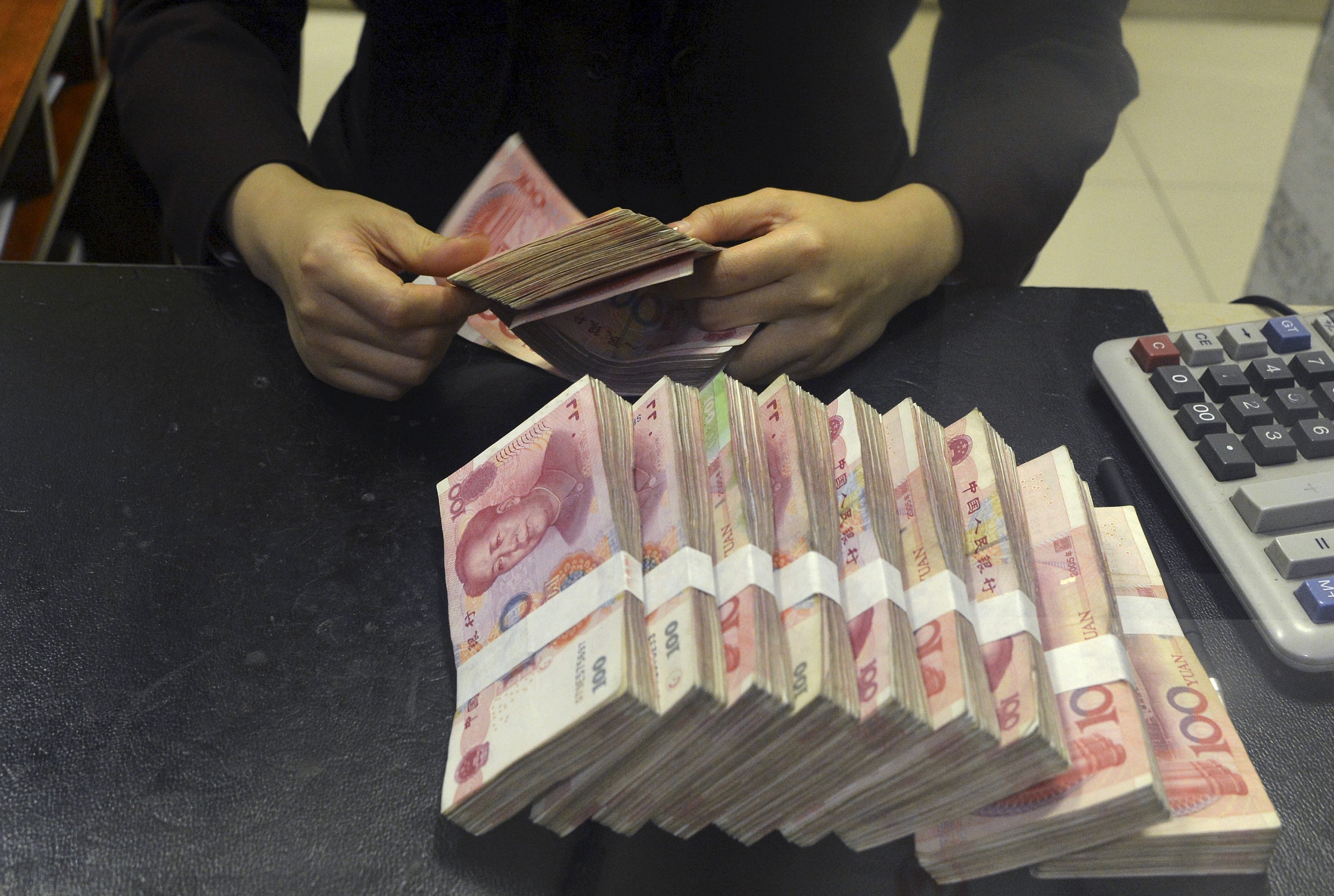 A clerk counts 100 yuan banknotes. China's central bank has cut the amount of cash that banks must hold as reserves, adding liquidity to the world's second-biggest economy. Photo: Reuters