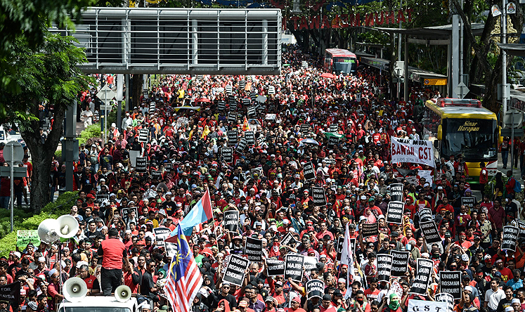 Protesters march towards Malaysia's landmark Petronas Twin Towers during a May Day protest against a goods and services tax in Kuala Lumpur on Friday. Photo: AFP