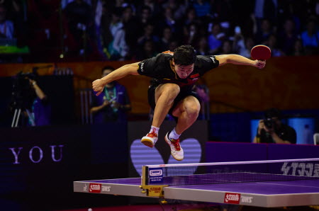 Ma Long jumps on the table after becoming world champion for the first time by beating Fang Bo in the final. Photo: Xinhua