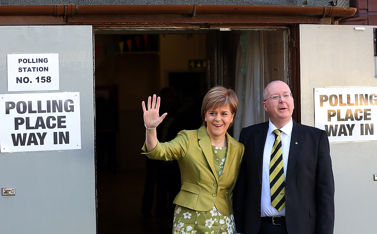 First Minister of Scotland and Scottish National Party leader Nicola Sturgeon and her husband Peter Murrell pose for photographs after casting her ballot at Broomhouse Community Hall. Photo: AP