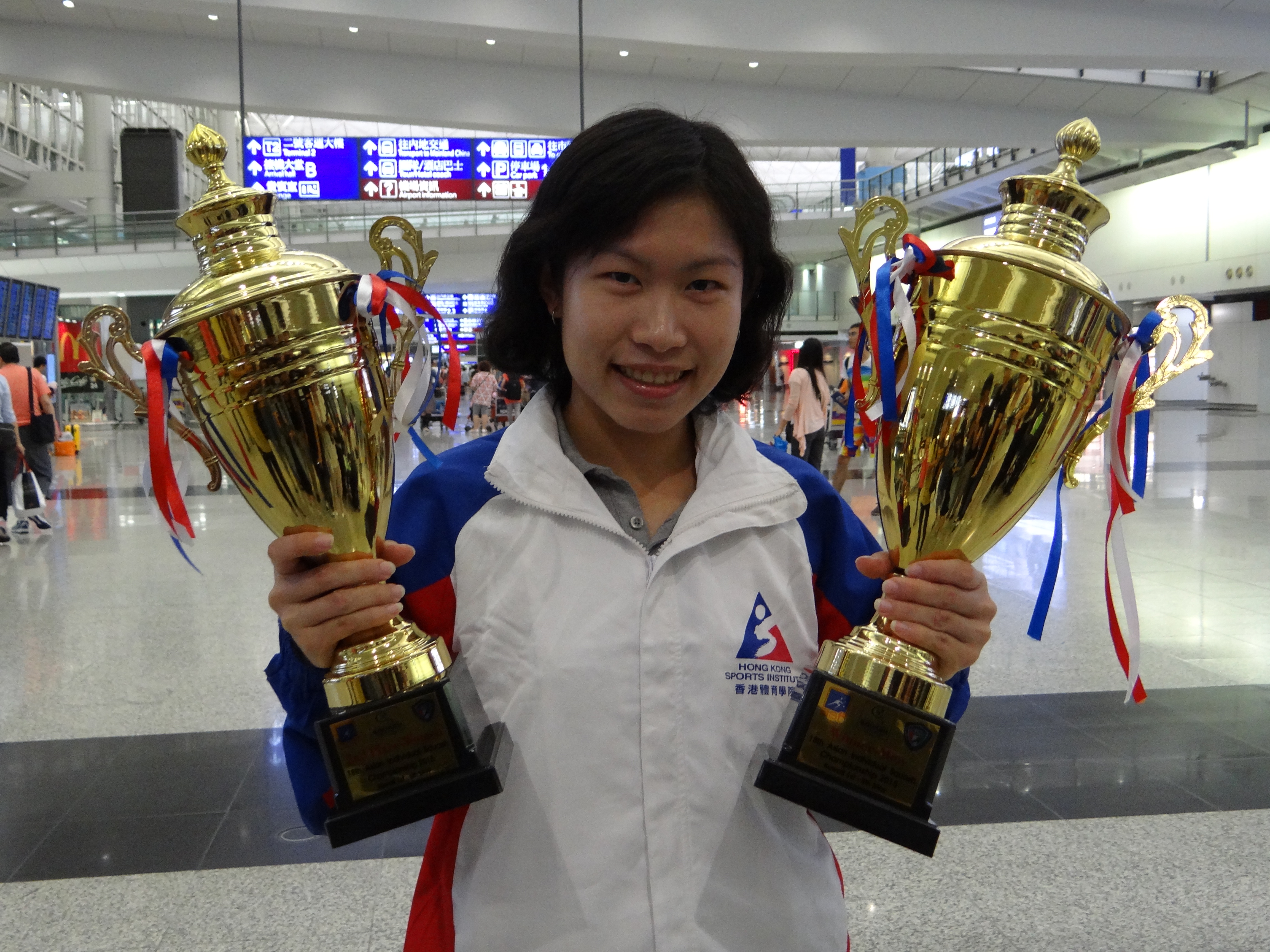 Annie Au with her trophy (left) and brother Leo's trophy on arriving back in Hong Kong. Photo Kevin Kung