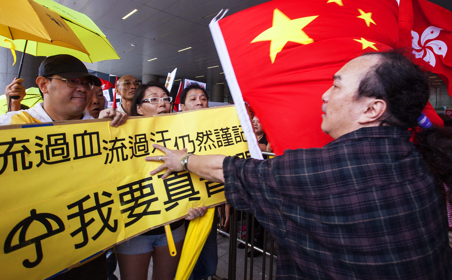 Supporters of the Hong Kong government's political reform package waving Chinese national and Hong Kong regional flags scuffle and exchange verbal abuse with protesters waving yellow umbrellas and banners opposing the Hong Kong government's proposal, Hong Kong on April 22, 2015. Photo: EPA