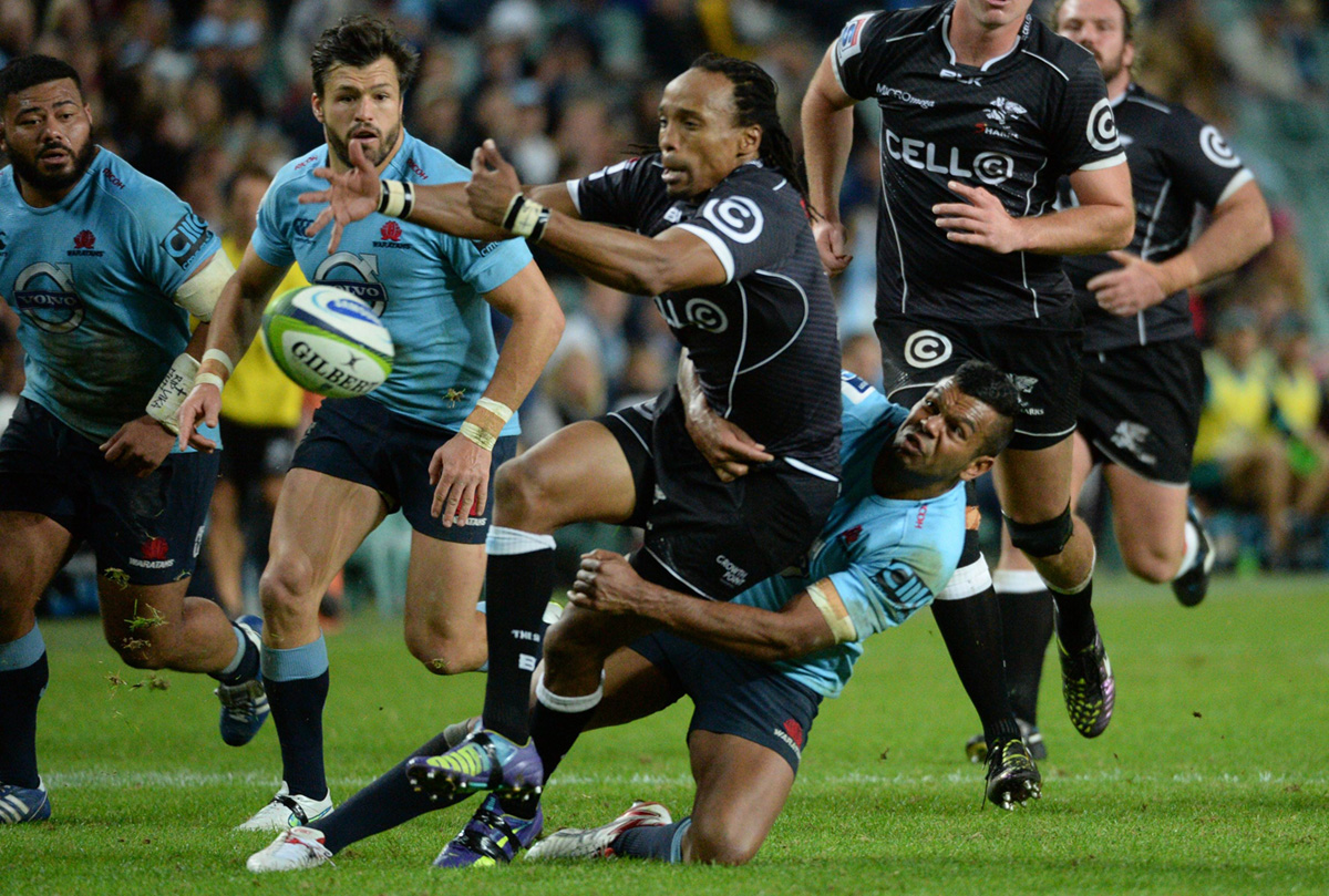 Kurtley Beale of the Waratahs tackles Sharks player Odwa Ndungane during their Super Rugby clash in Sydney on Saturday. Photo: AFP