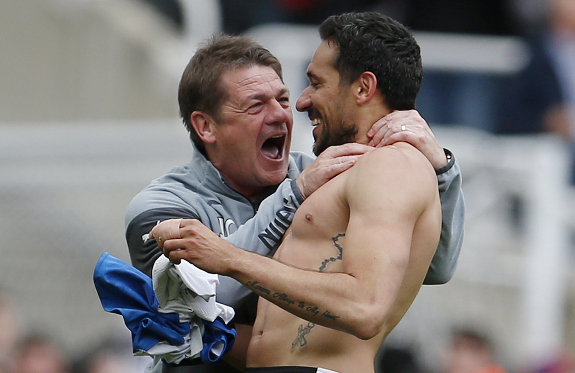 Manager John Carver almost strangles Jonas Gutierrez in delight after the Argentine sealed Newcastle's survival. Photos: Reuters