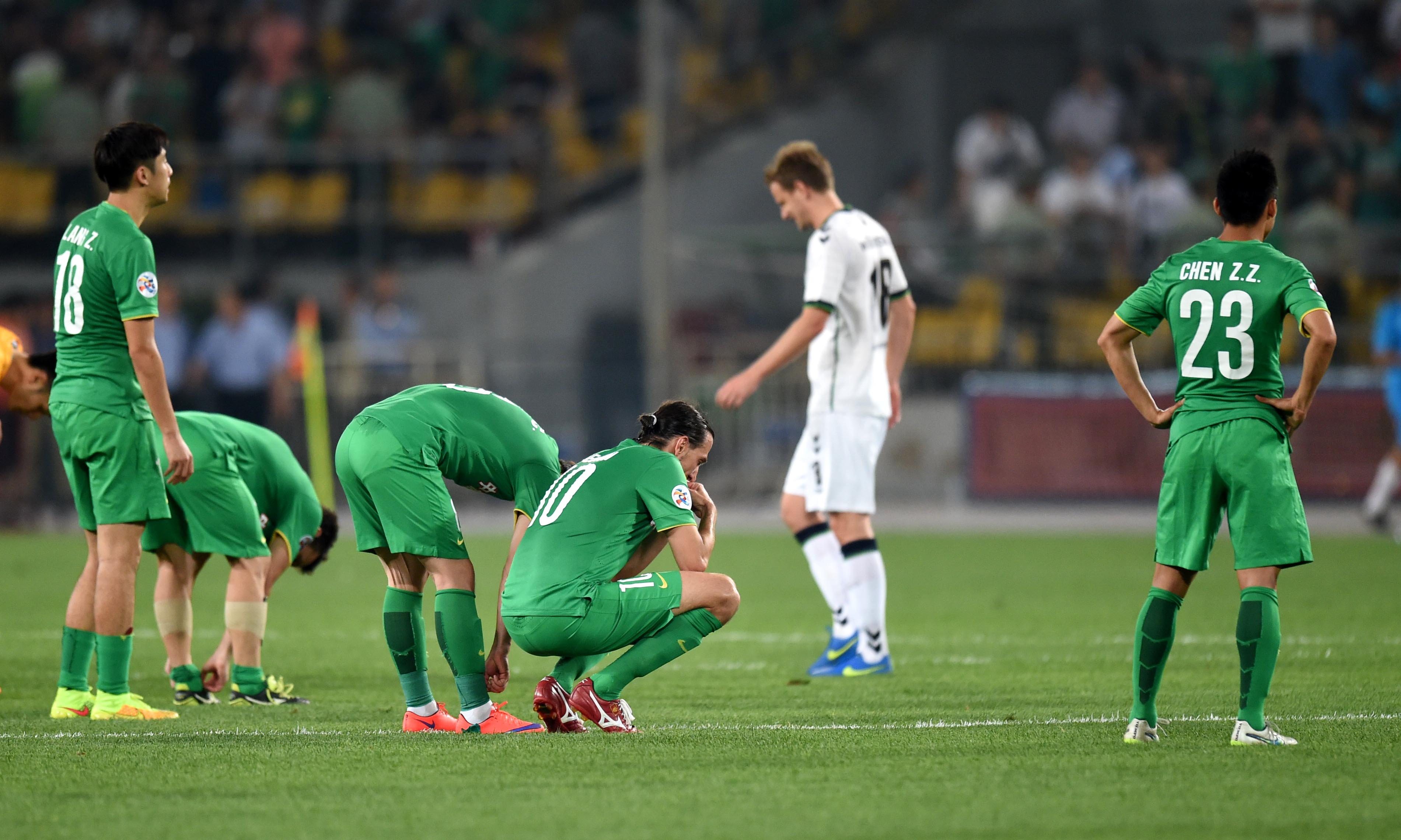 Deflated Beijing Guoan players come to terms with being knocked out of the competition at the last 16 stage. photo: Xinhua