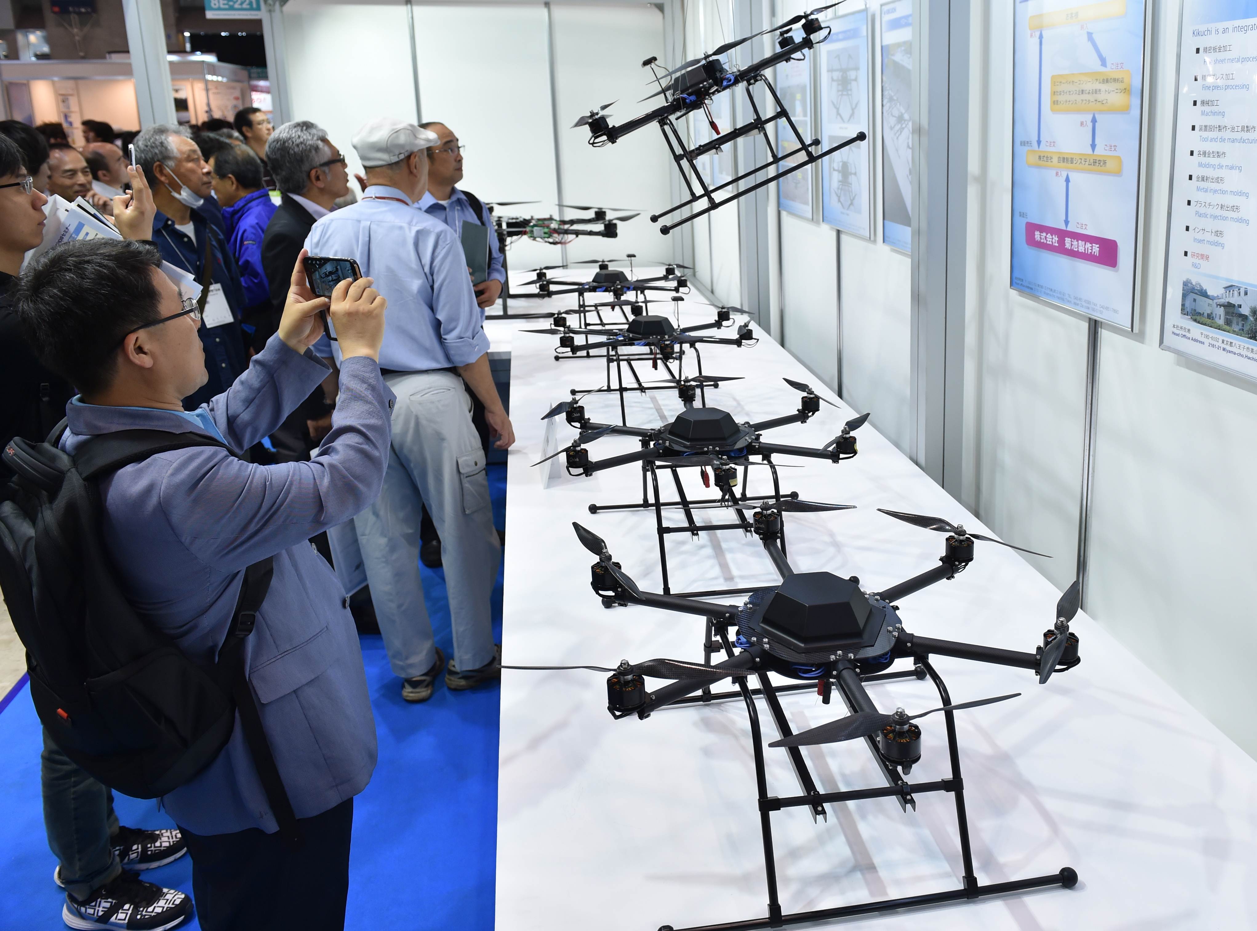 Visitors gather in front of an exhibition booth displaying recent models of drones during the International Drone Expo in Tokyo on May 20, 2015. Photo: AFP