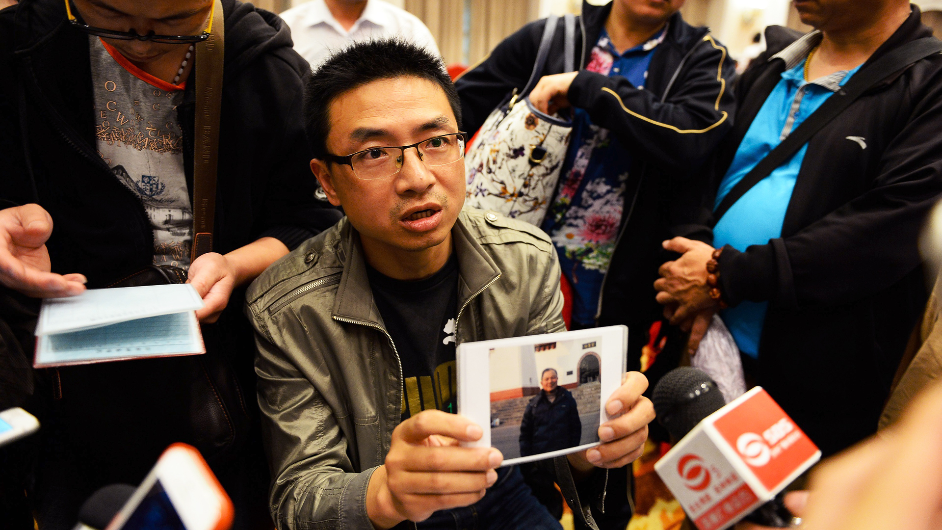 A man shows a photo of his father-in-law, who was on board the Eastern Star. Photo: TNS