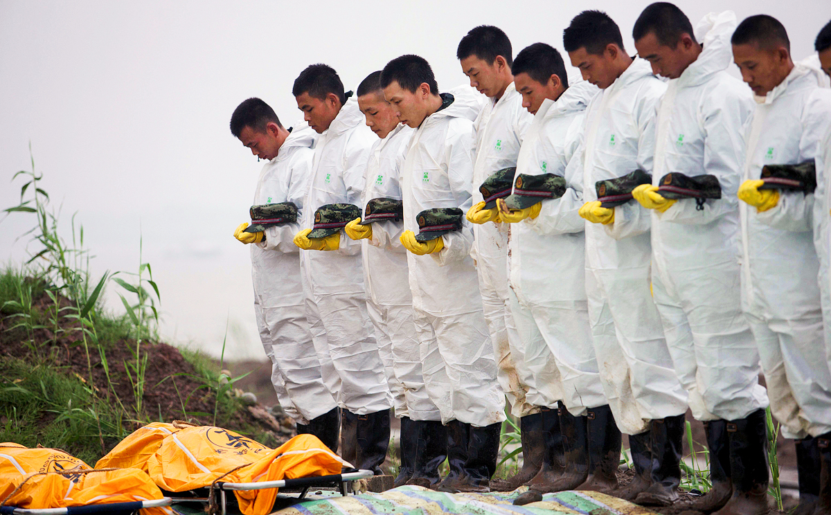 Rescue workers pay respects to victims of the Eastern Star disaster. The ship sank on the Jianli section of the Yangtze River. Photo: Reuters