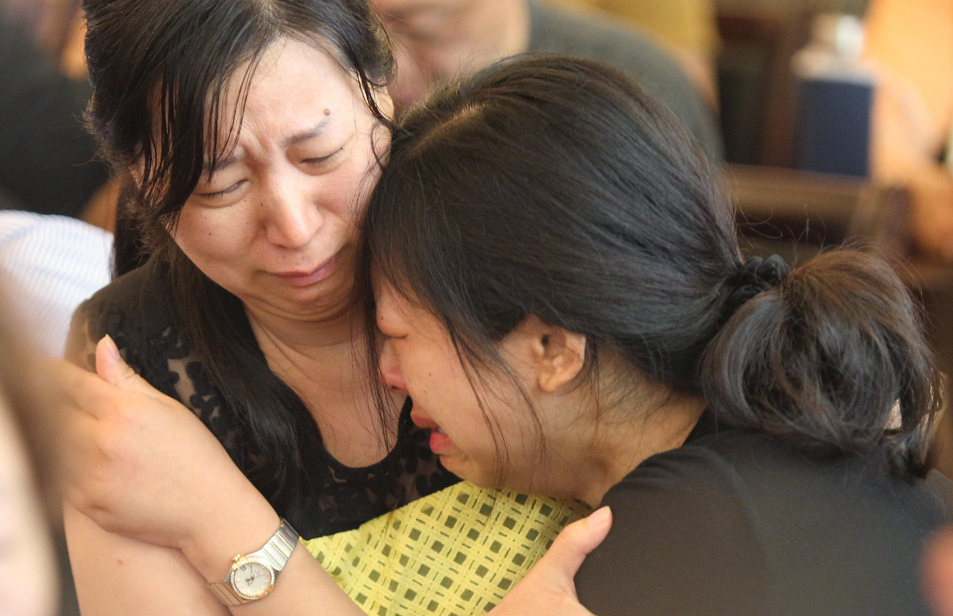 Two women cry at a meeting with officials in Jianli county. Photo: Simon Song. 