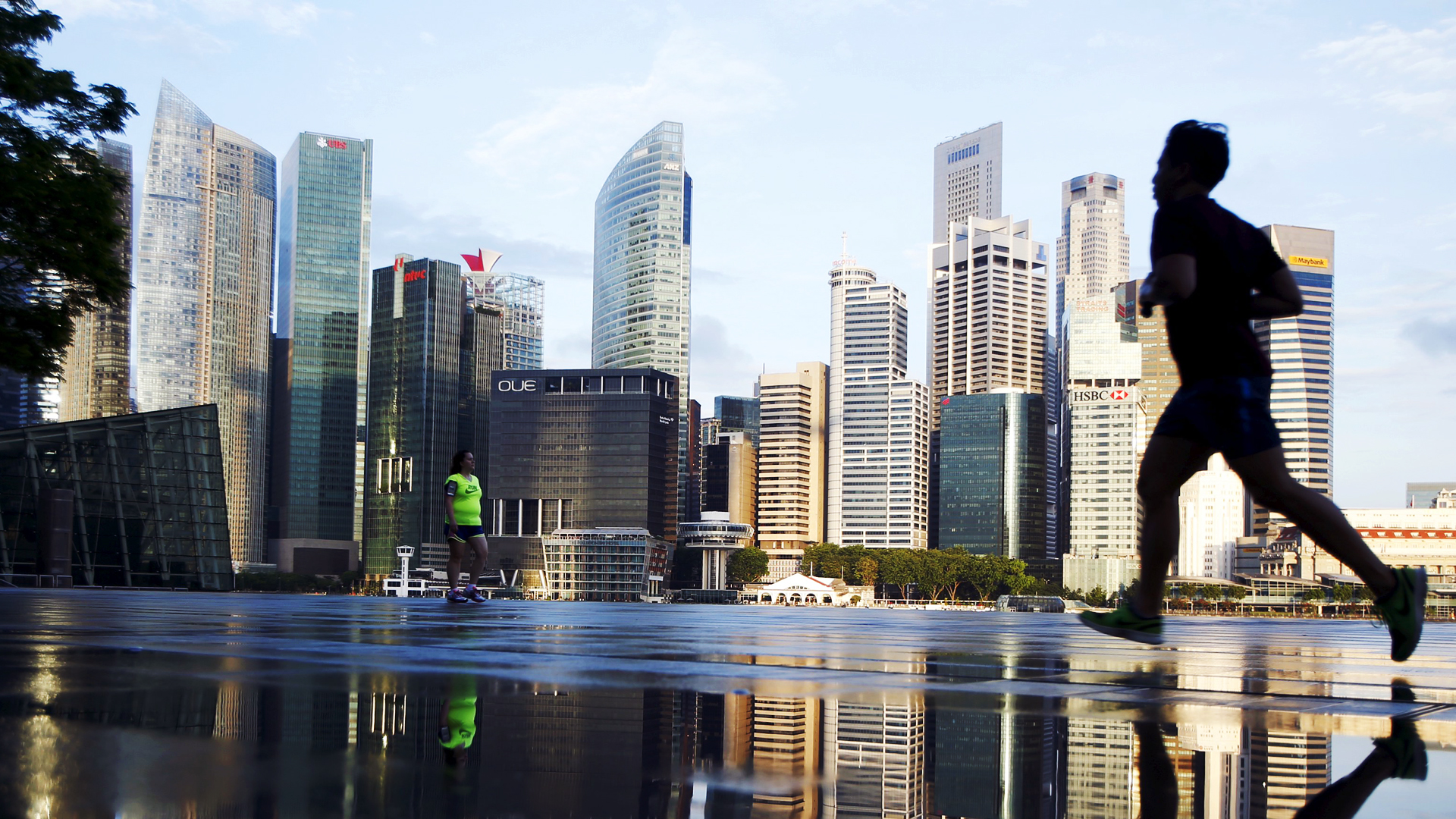 Joggers pass the skyline of the central business district in Singapore. Photo: Reuters