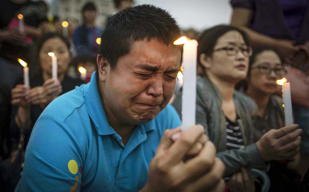 Locals and relatives of the victims hold a candlelight vigil for the victims on the stricken cruise ship. Photo: EPA