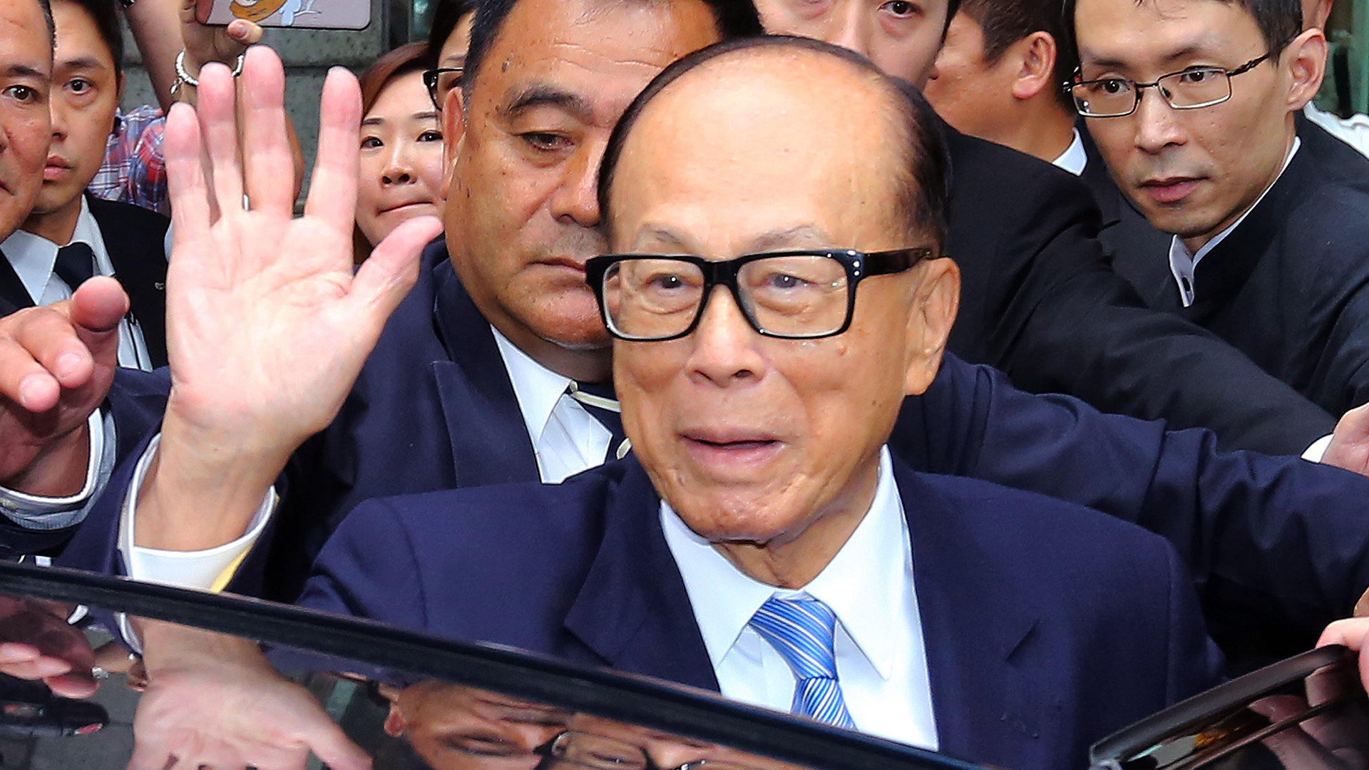 Billionaire Li Ka-shing waves while about to get into his car. The tycoon's Power Assets Holdings has sold a 16.5 per cent stake in Hong Kong Electric Investments to Qatar's sovereign wealth fund. Photo: Handout
