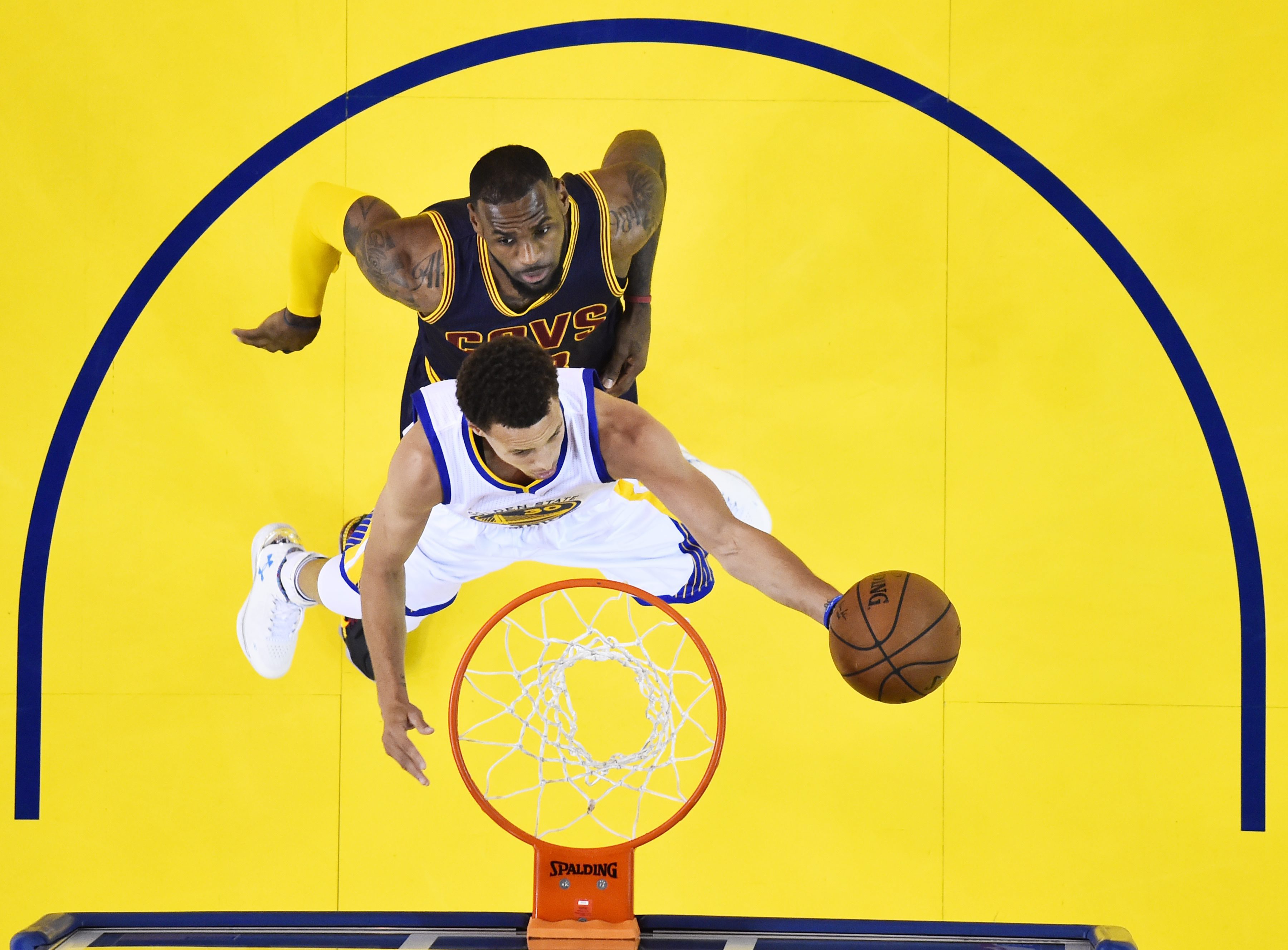 LeBron James tries to block a shot against  Stephen Curry. Photo: EPA