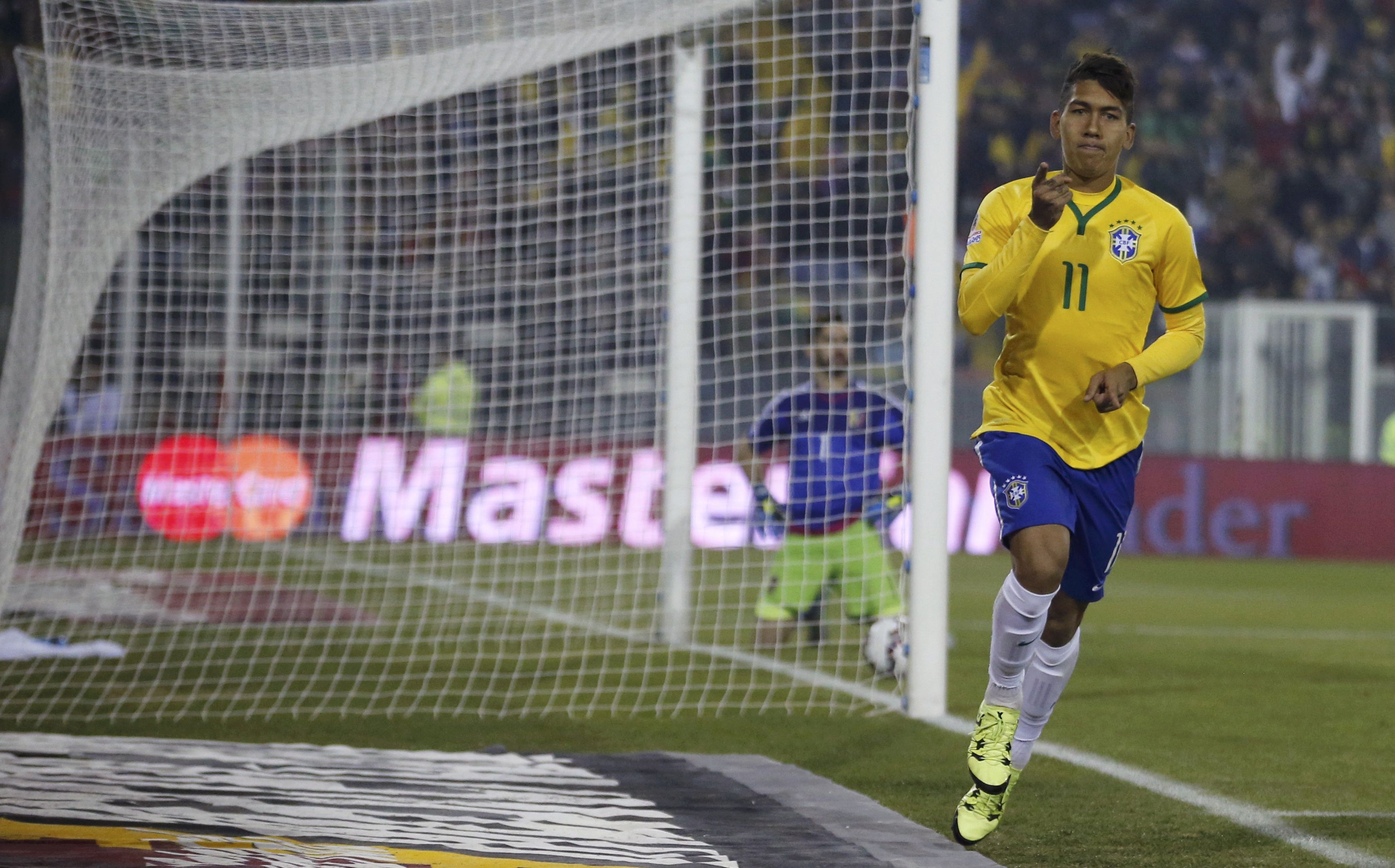 Brazil's Roberto Firmino scores past Venezuela's goalie Alain Baroja. Photo: Reuters