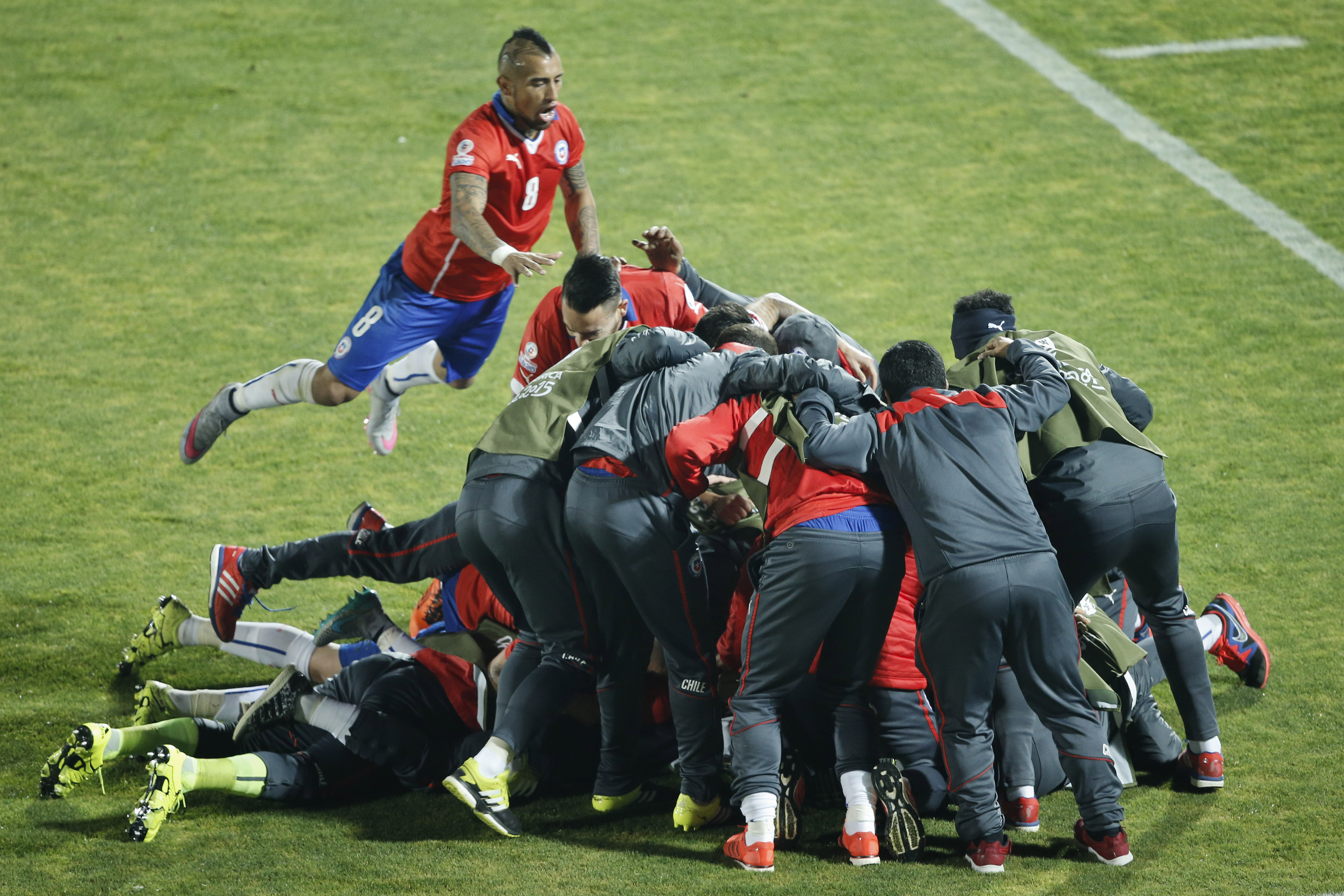 Chile's Arturo Vidal, left, jumps on top of teammates as they celebrate Mauricio Isla's winner. Photo: AP