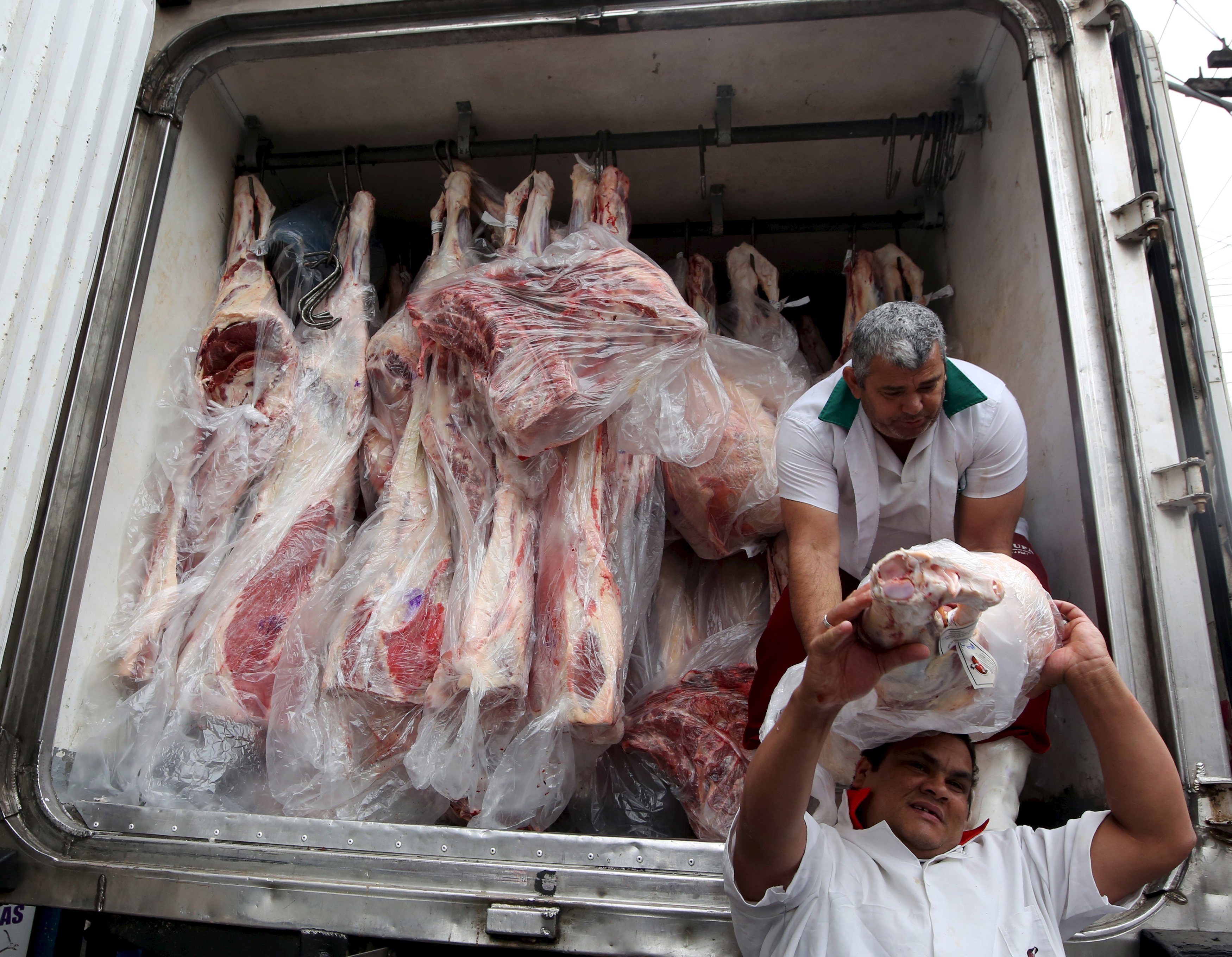 Workers unload packed meat from a truck in Sao Paulo. Photo: Reuters