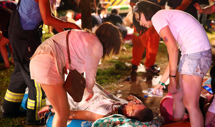 Women comfort a friend injured in the fire at Formosa Fun Coast. Photo: Xinhua
