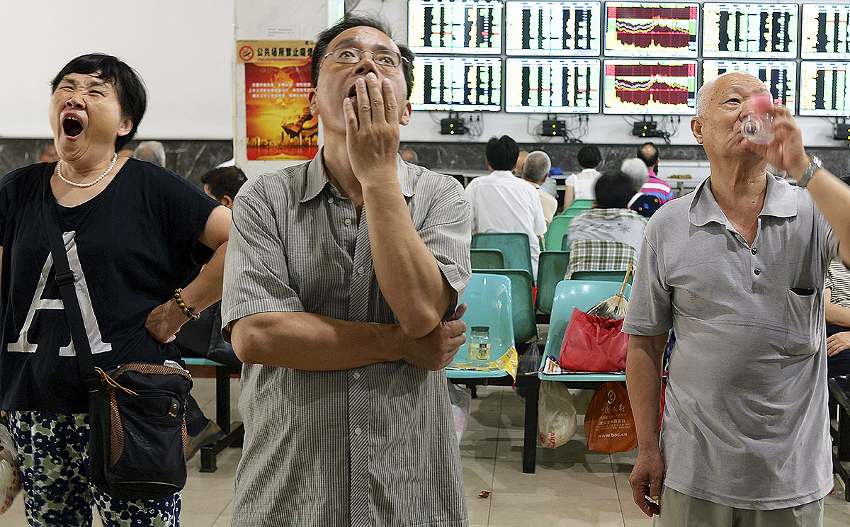 Investors watch computer screens showing stock information at a brokerage house in Wuhan. Photo: Reuters