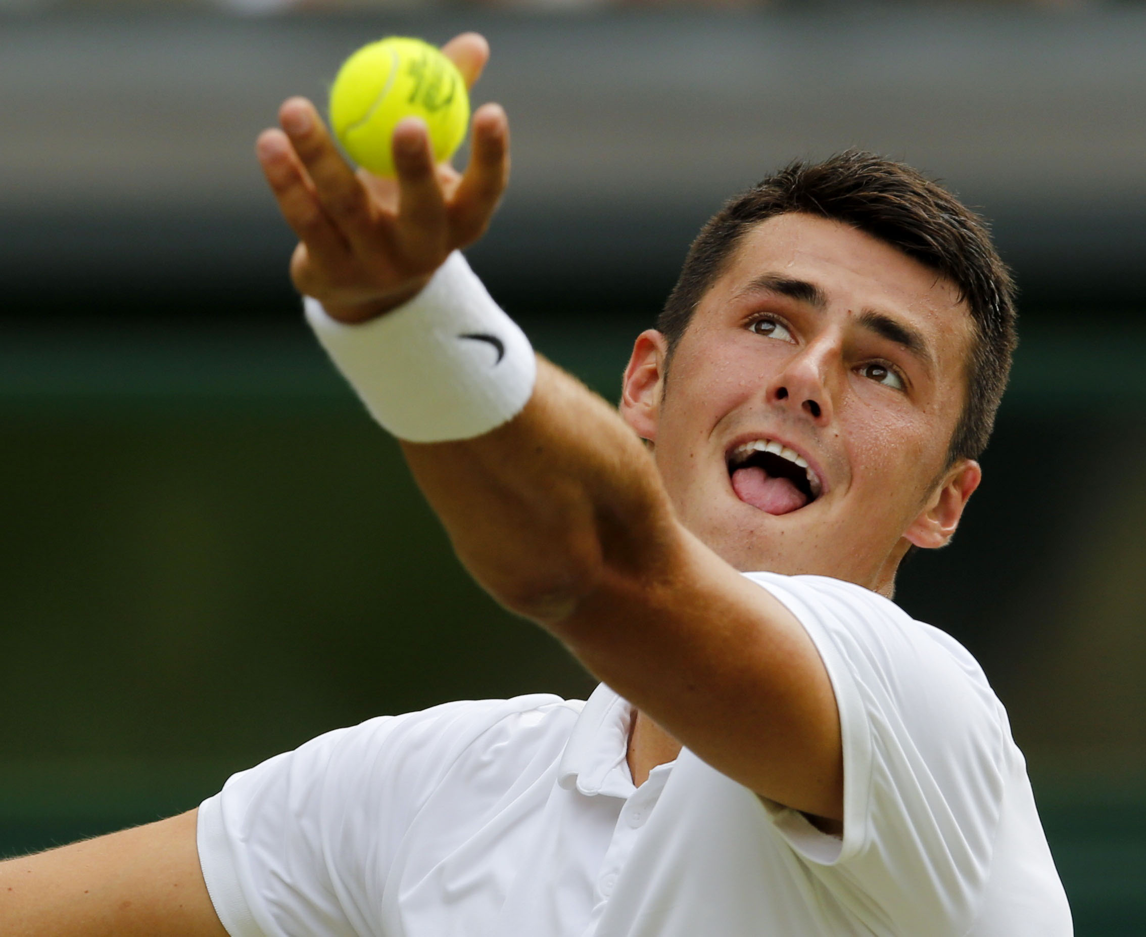 Bernard Tomic serves during his straight-sets loss to Novak Djokovic, but the Aussie saved his best shots for after the match. Photo: Reuters