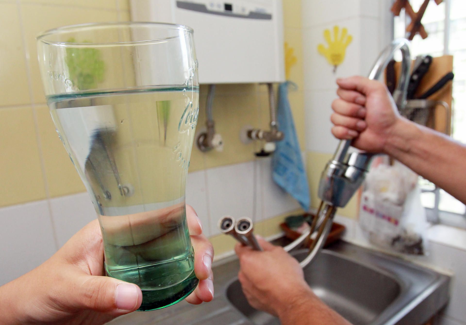 Experts take water samples from a flat in Kai Ching estate in Kowloon City. They found excessive lead levels. Photo: May Tse